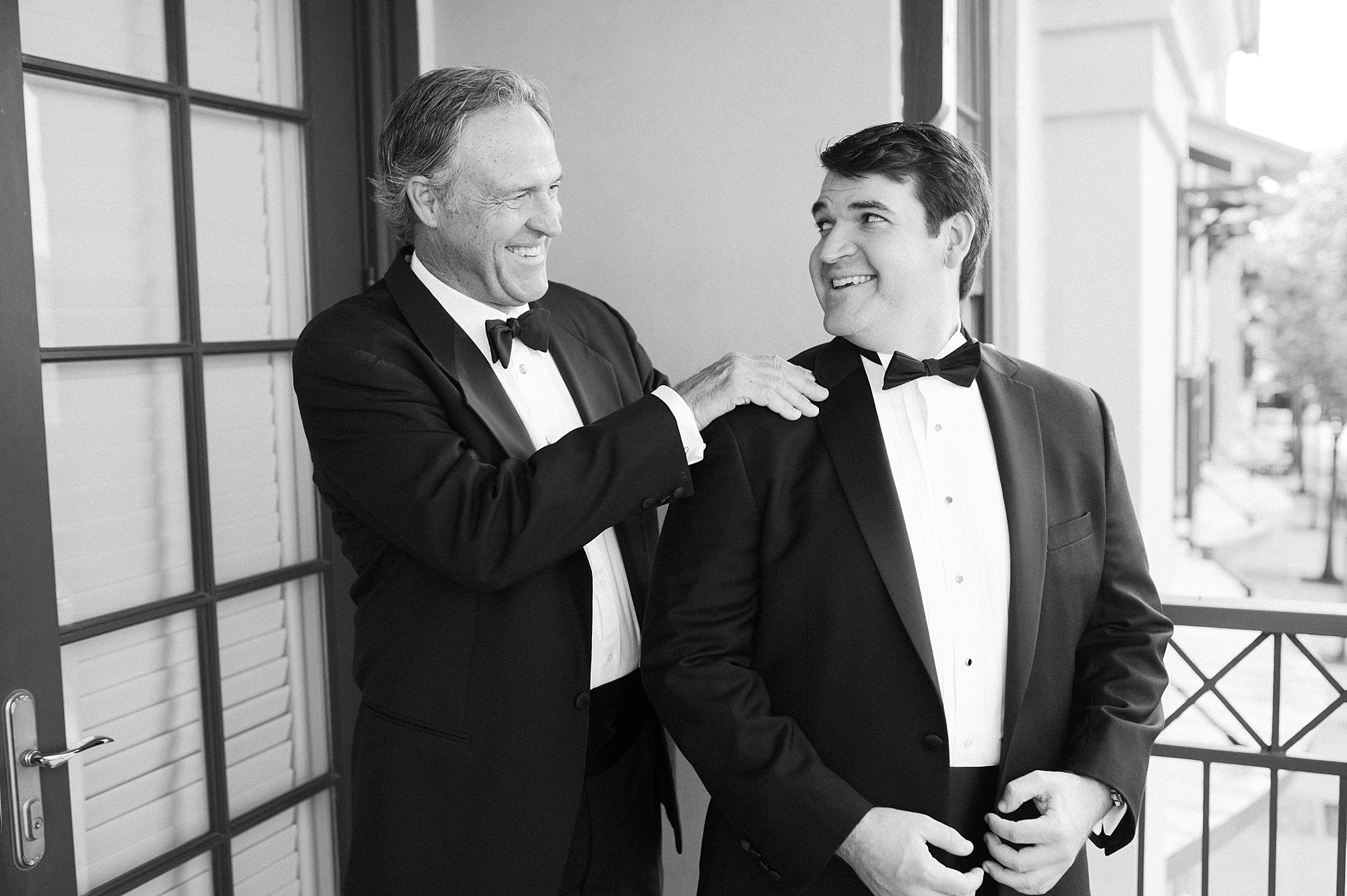 father helps groom adjust tie and suit jacket before Louisiana wedding