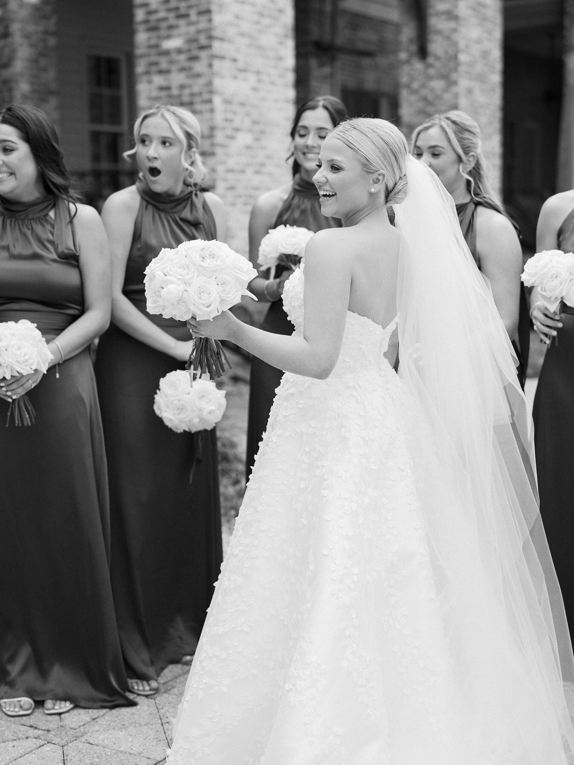 bride faces bridesmaids in blue gowns for first look before Louisiana wedding