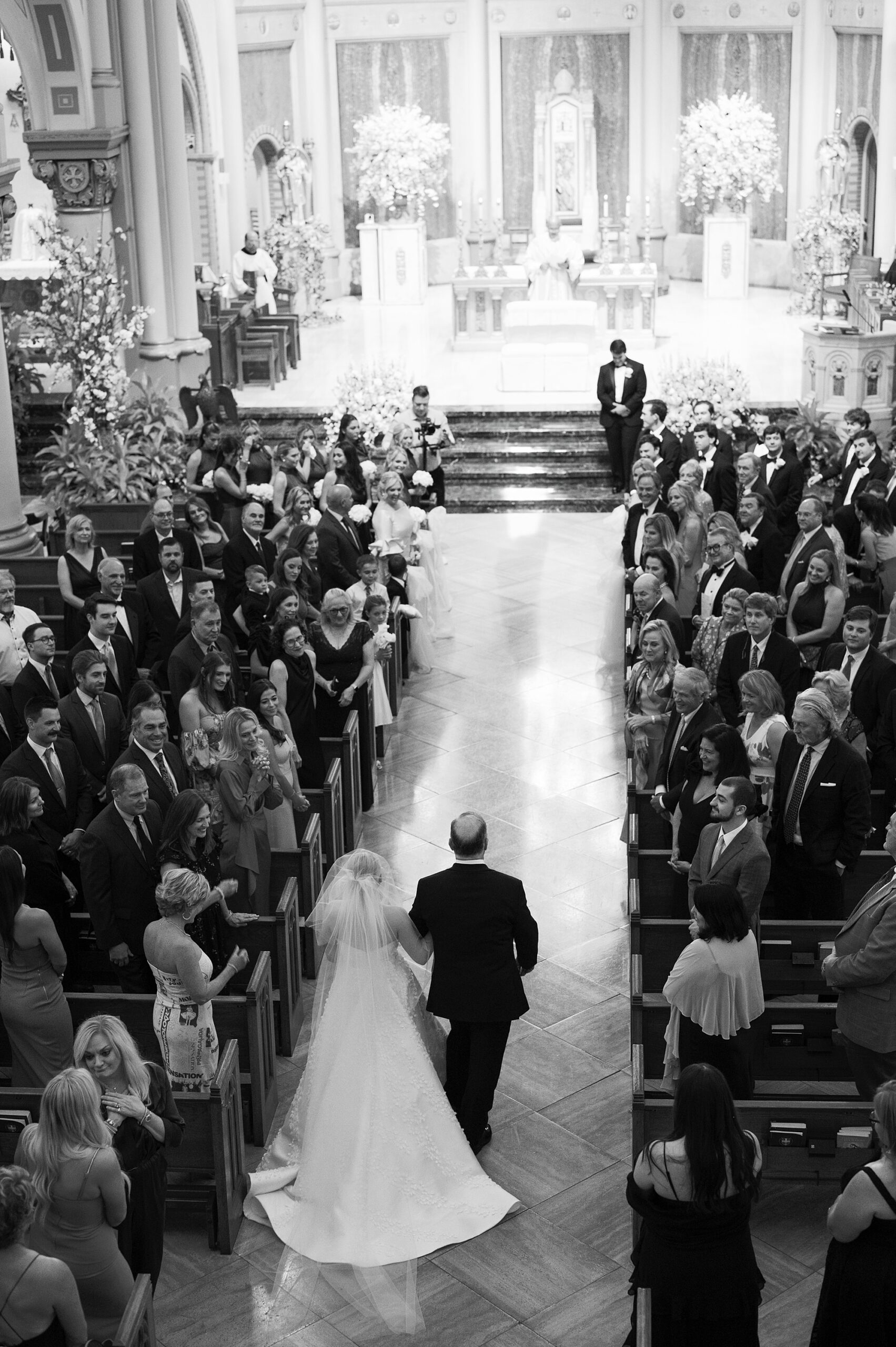 bride and father walk down aisle for traditional Catholic Church wedding at St. John Cathedral