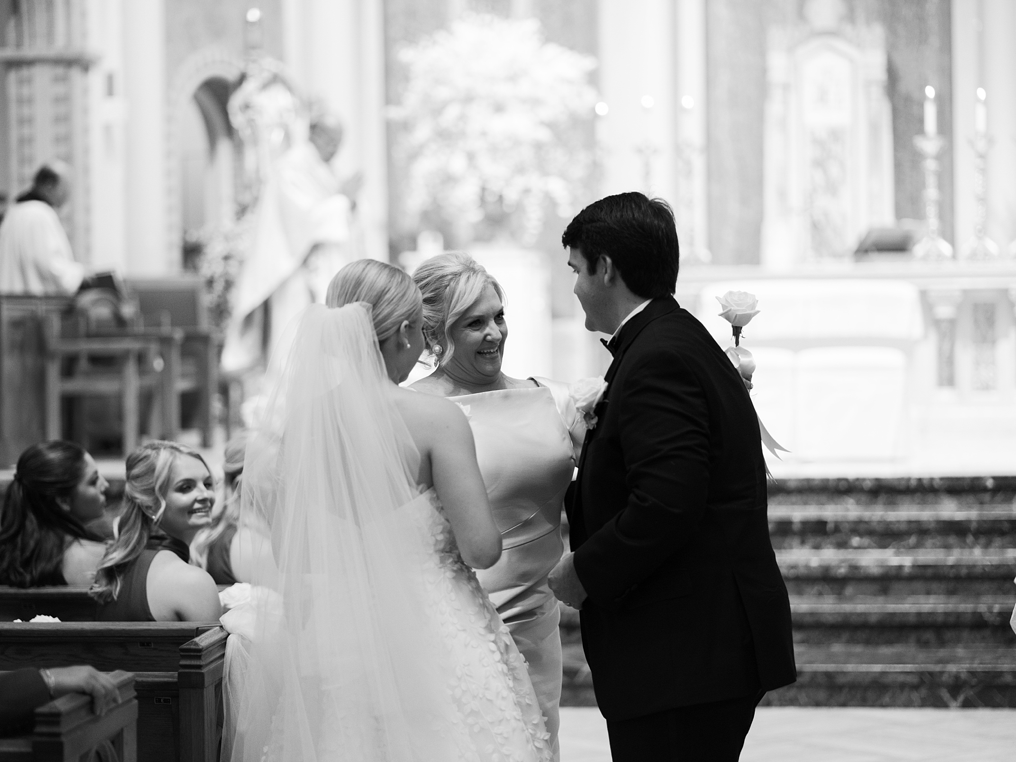 mother of groom speaks to couple during traditional Catholic Church wedding at St. John Cathedral