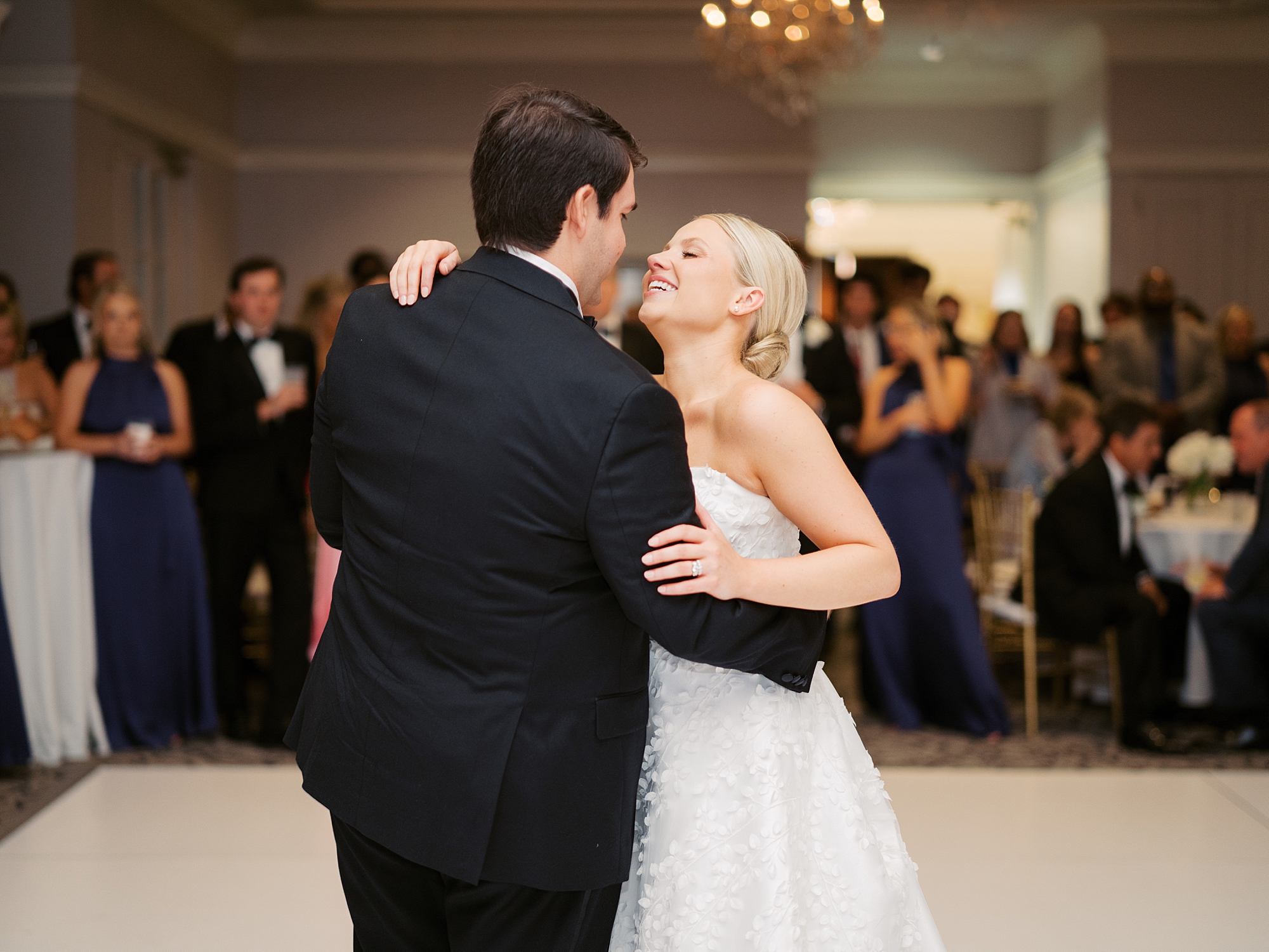 blonde bride laughs up at groom during first dance of LA wedding reception 