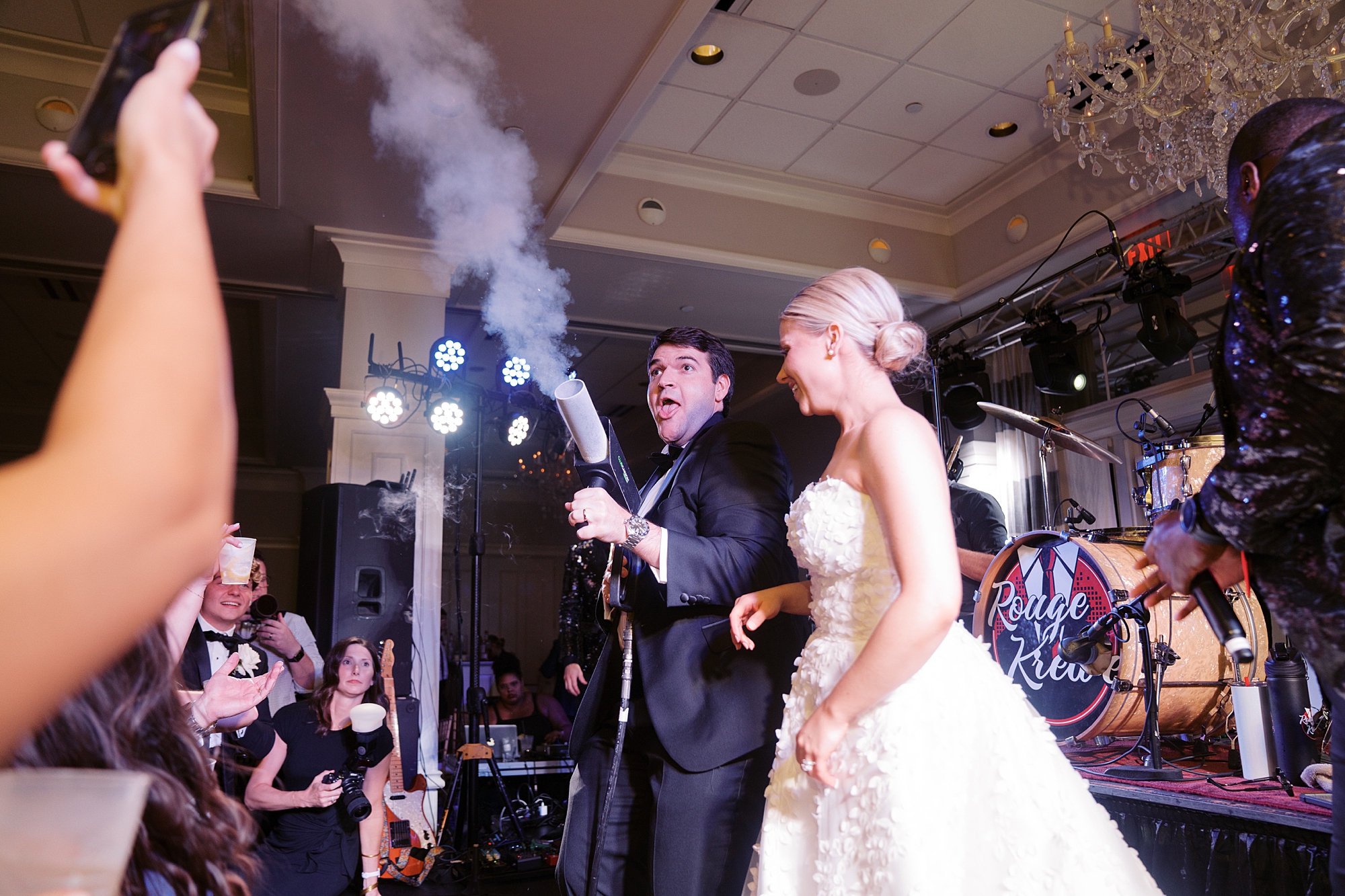 groom holds smoke machine over dance floor during wedding reception at City Club at River Ranch