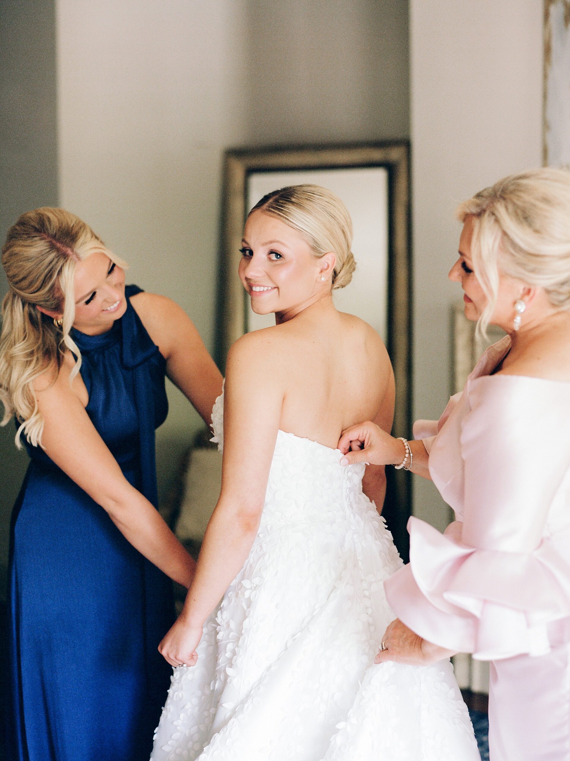 sister and mother help bride prepare for wedding day in Lafayette LA