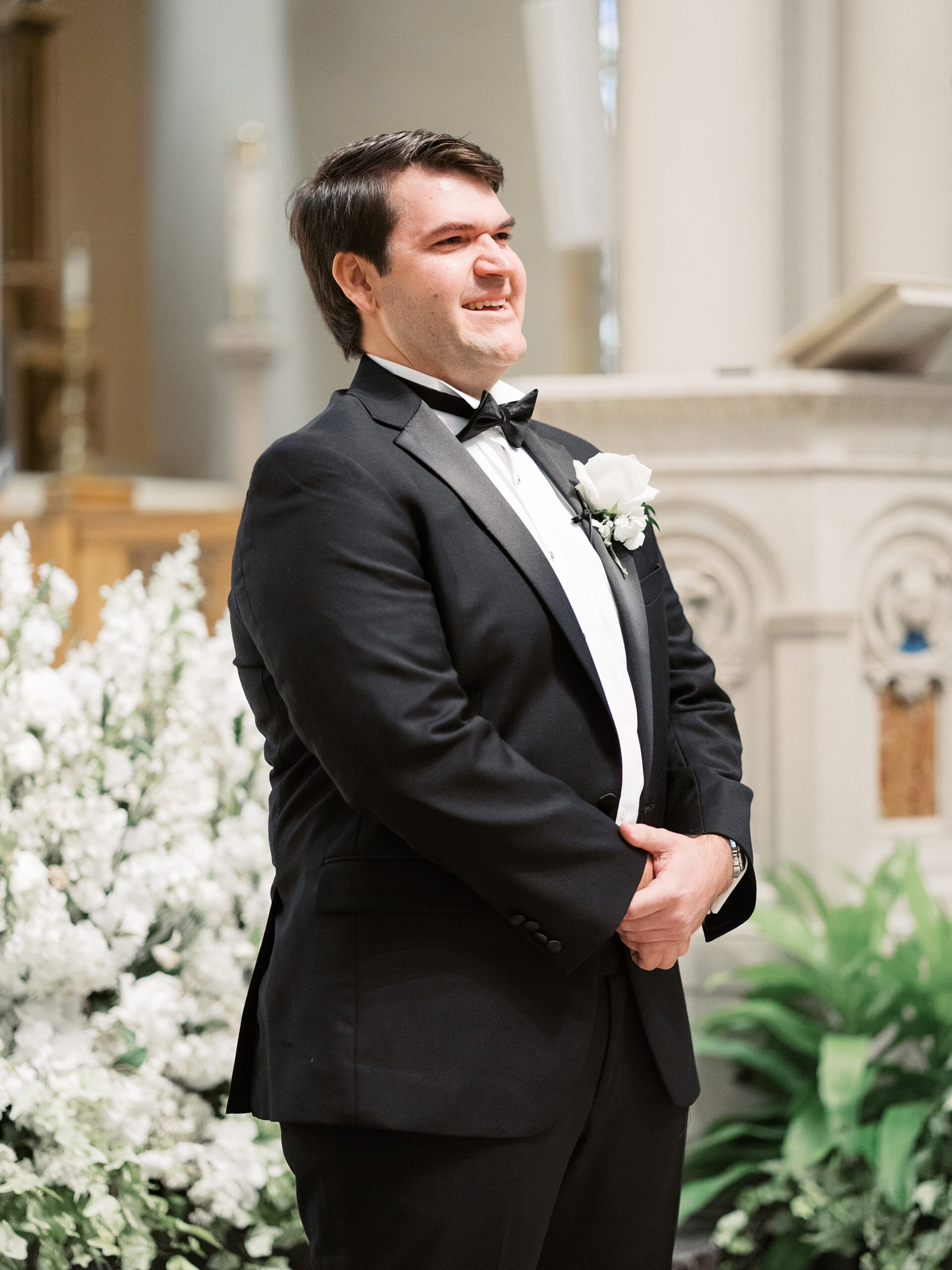 groom stands at the front of St. John's Cathedral  waiting for bride 