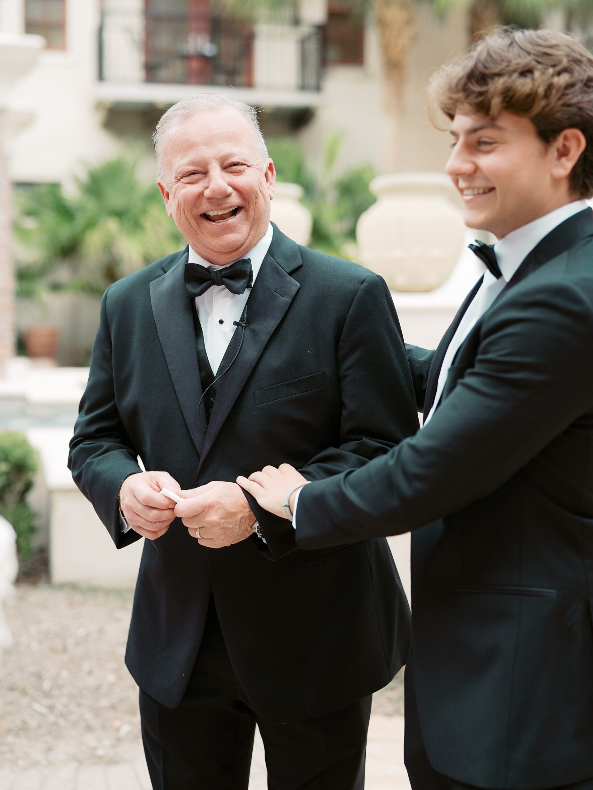 bride's father and brother laugh together during portraits 