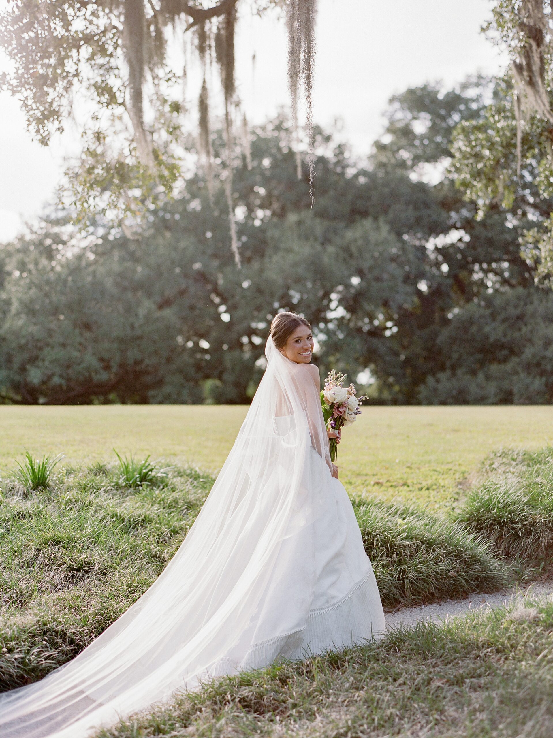 bride walks through Rip Van Winkle gardens during bridal portraits on Jefferson Island 