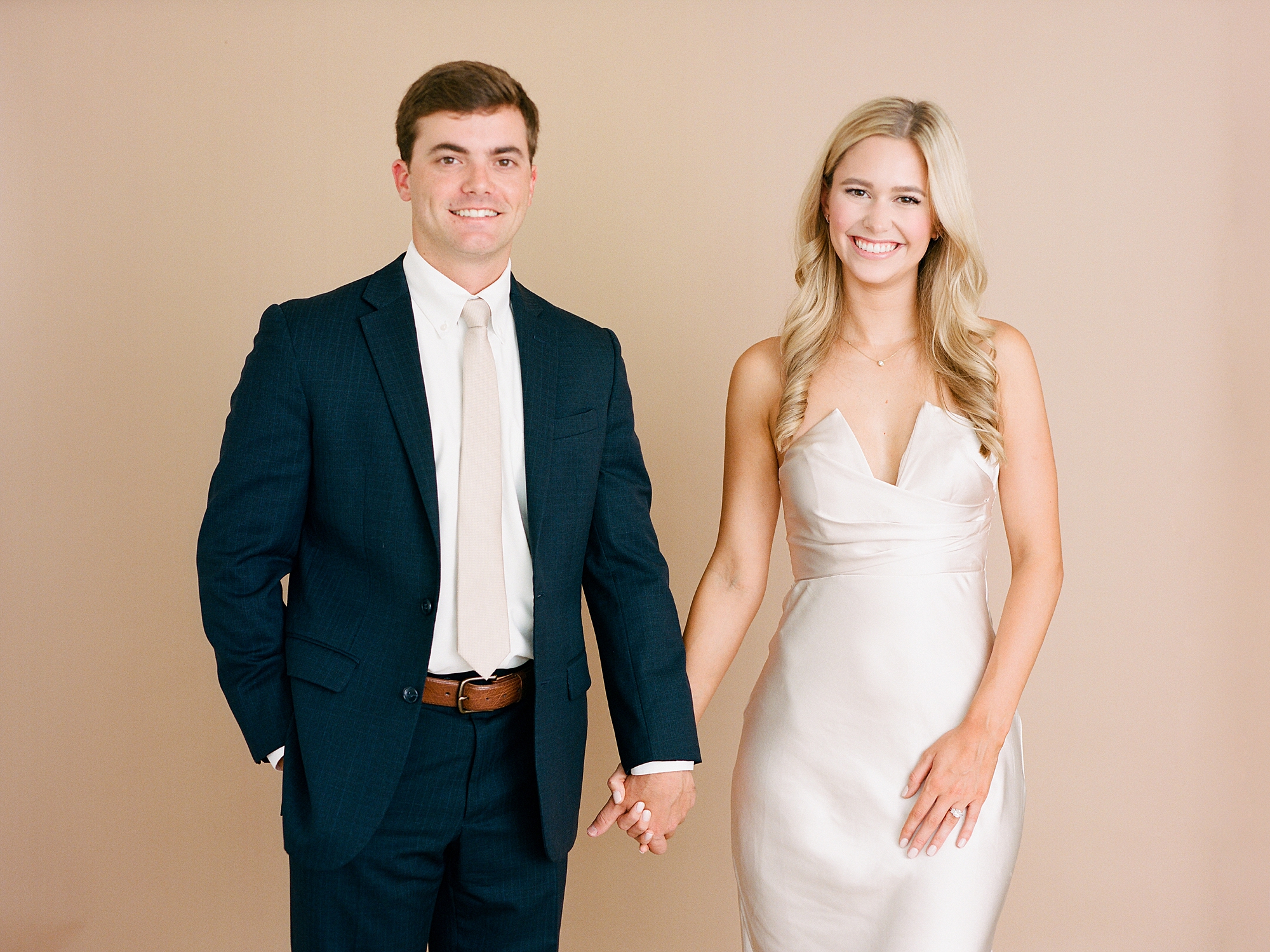 man and woman hold hands during studio engagement portraits in Louisiana 