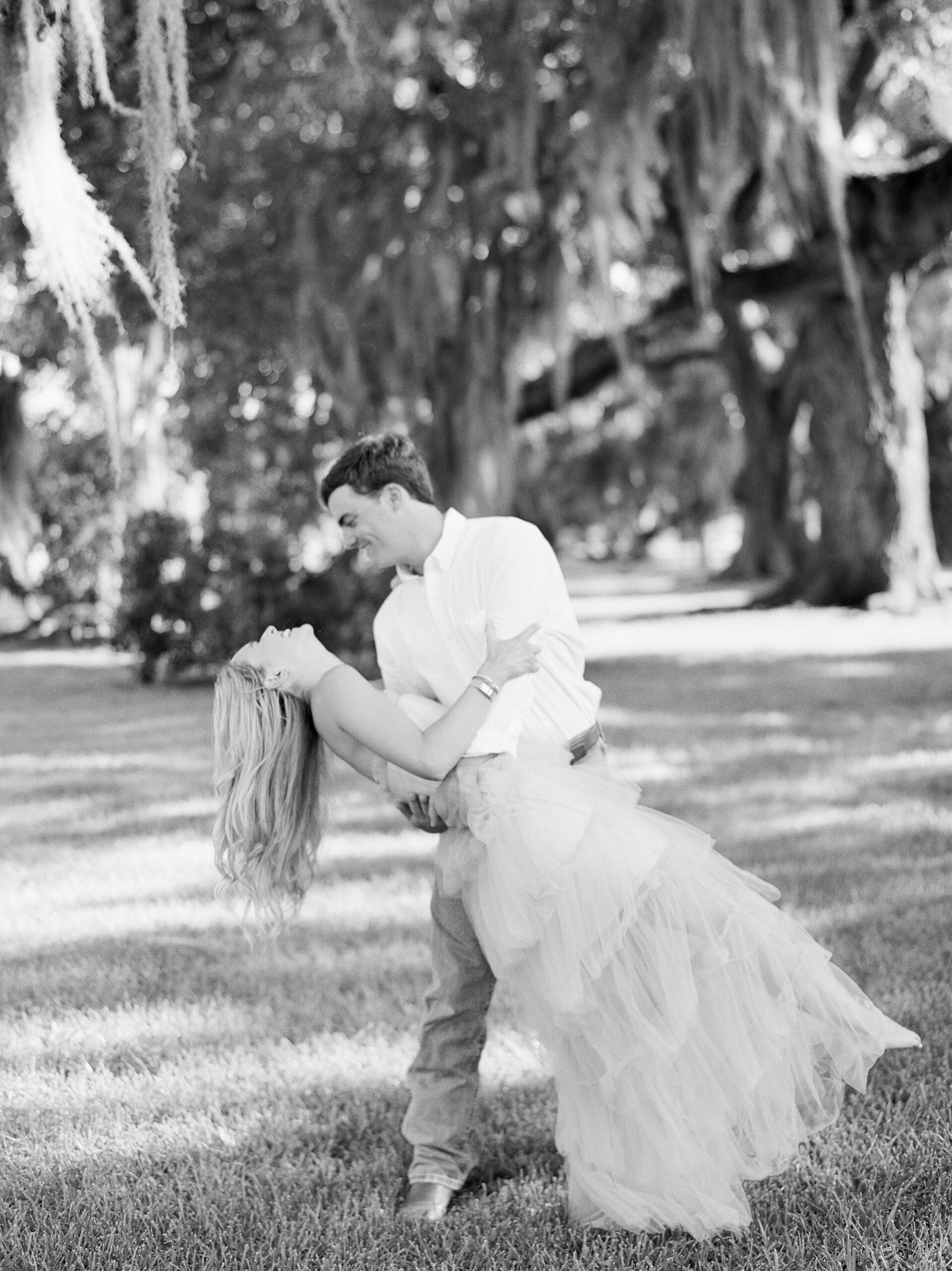 man dips woman in frilly dress during Sacred Heart of Grand Coteau engagement session 