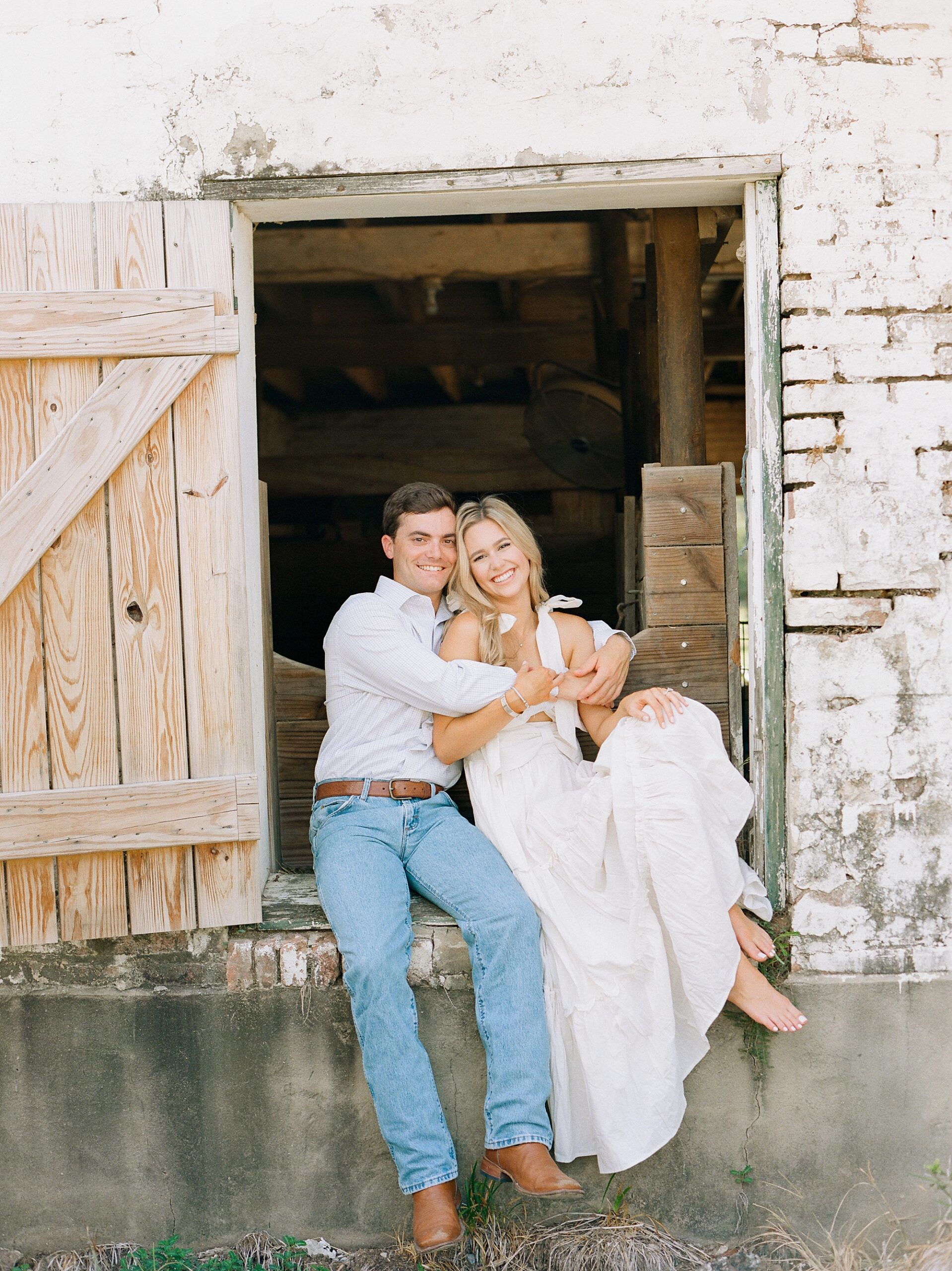 engaged couple sits in stone doorway at Sacred Heart of Grand Coteau