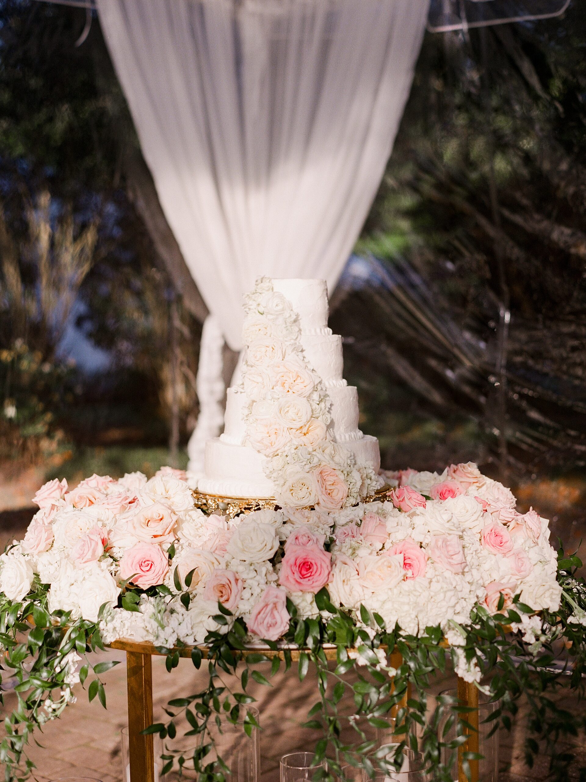 tiered wedding cake with pink and white roses at the University of Louisiana at Lafayette alumni center