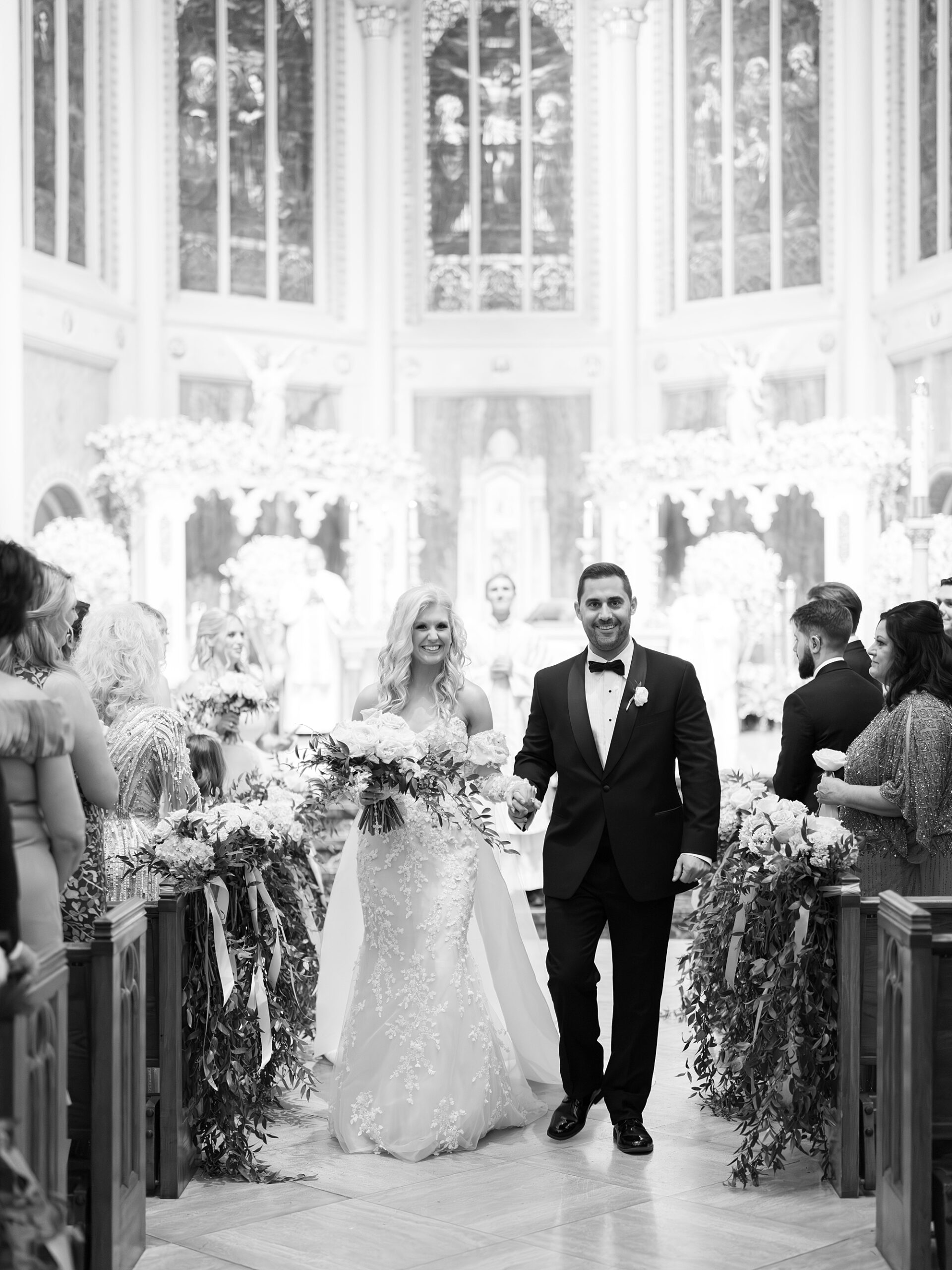 newlyweds walk up aisle after Cathedral Of St. John during traditional Catholic wedding ceremony