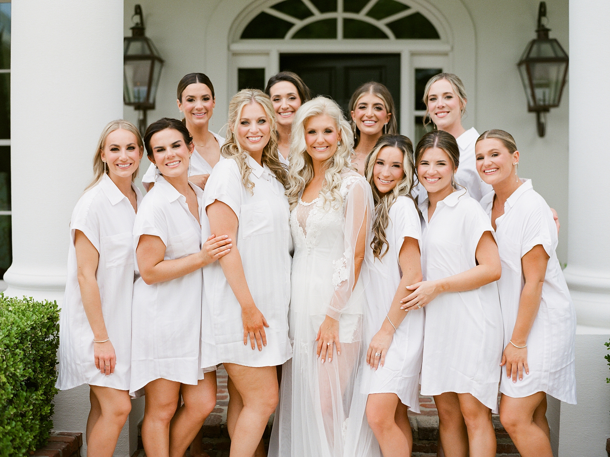bride stands on steps surrounded by bridesmaids outside the University of Louisiana at Lafayette