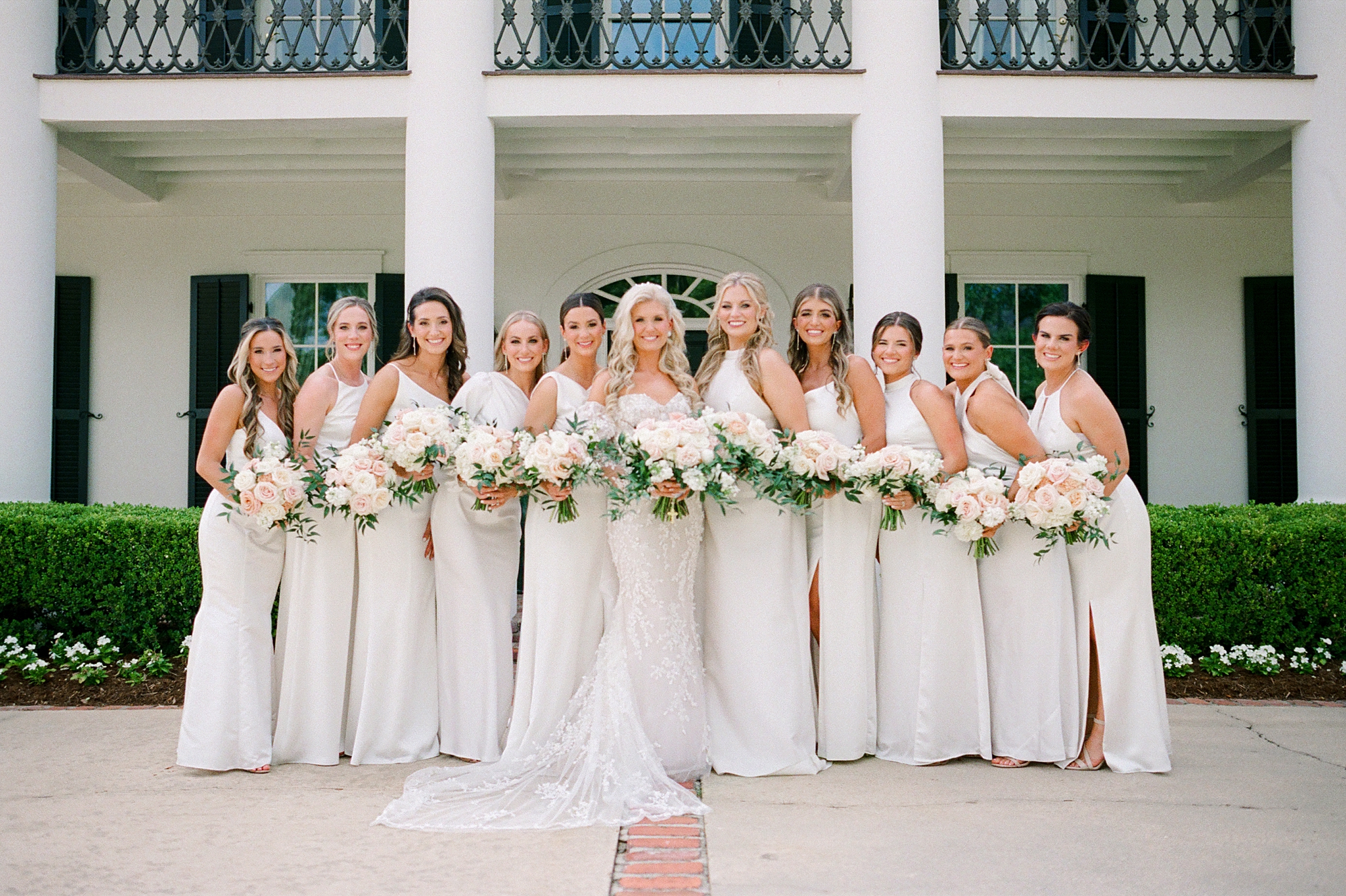 bride and bridesmaids pose outside the University of Louisiana at Lafayette alumni center