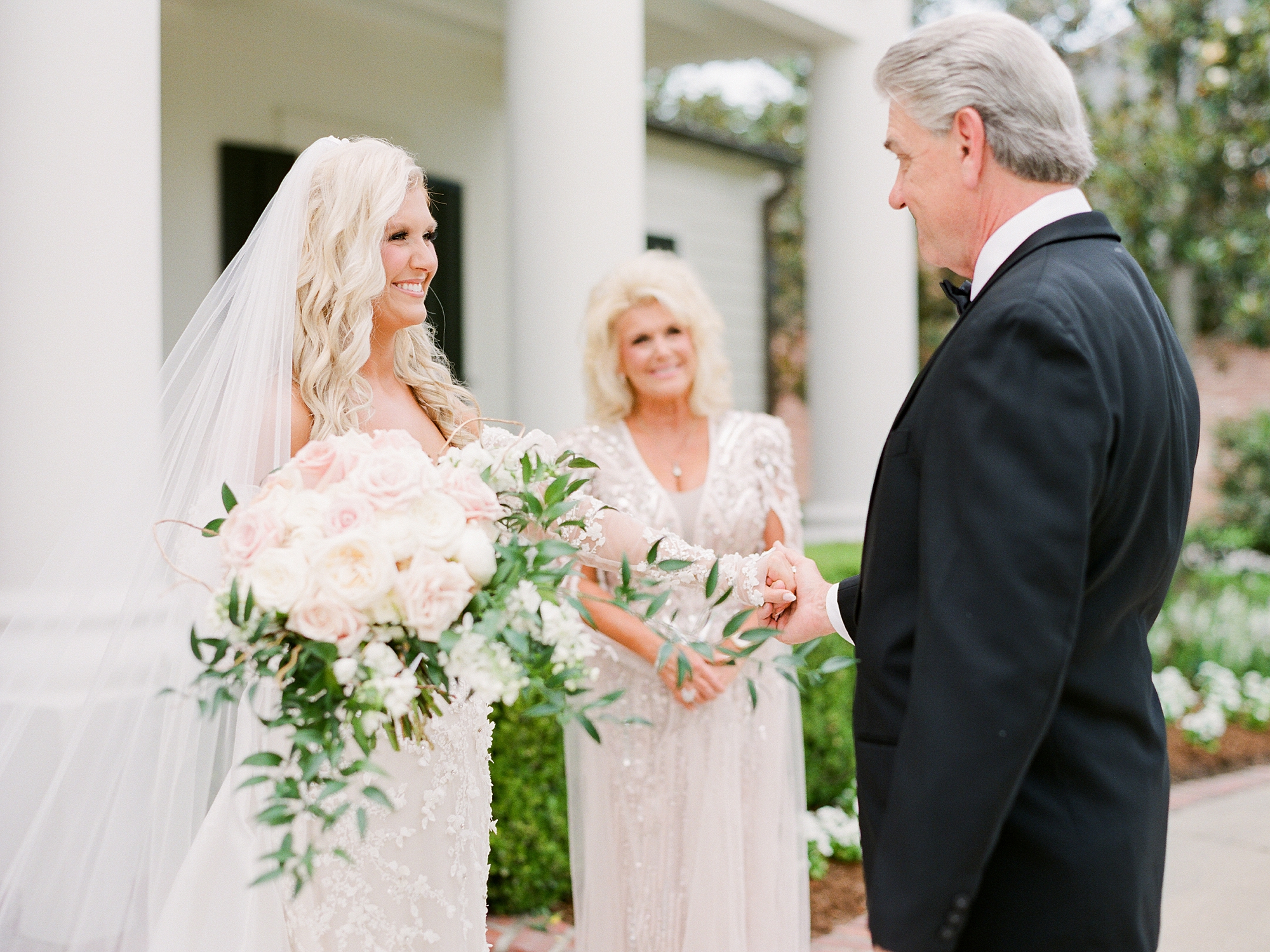 bride smiles at father during first look outside the University of Louisiana at Lafayette alumni center