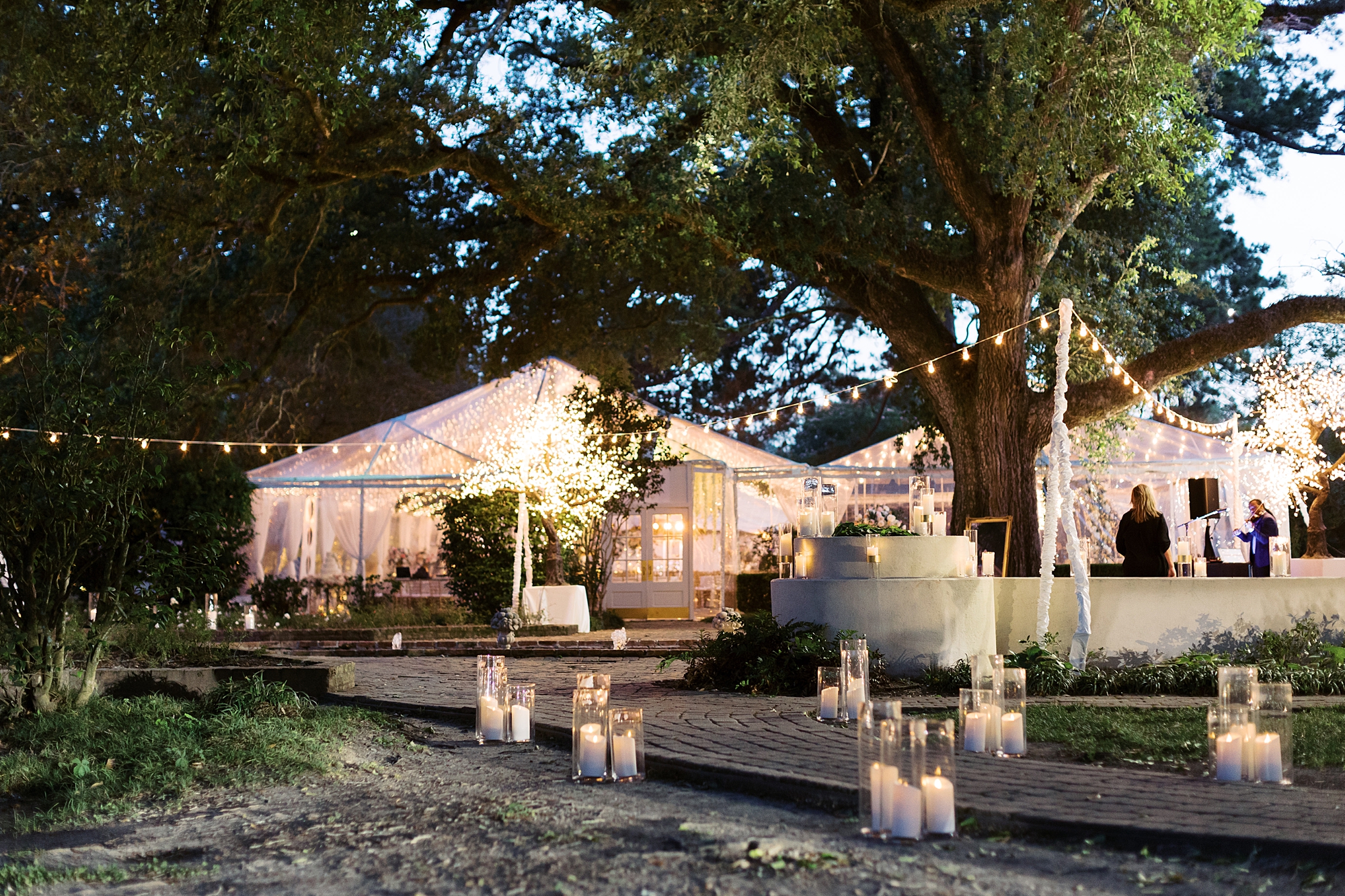 tented wedding reception with candles and pink roses at the University of Louisiana at Lafayette alumni center