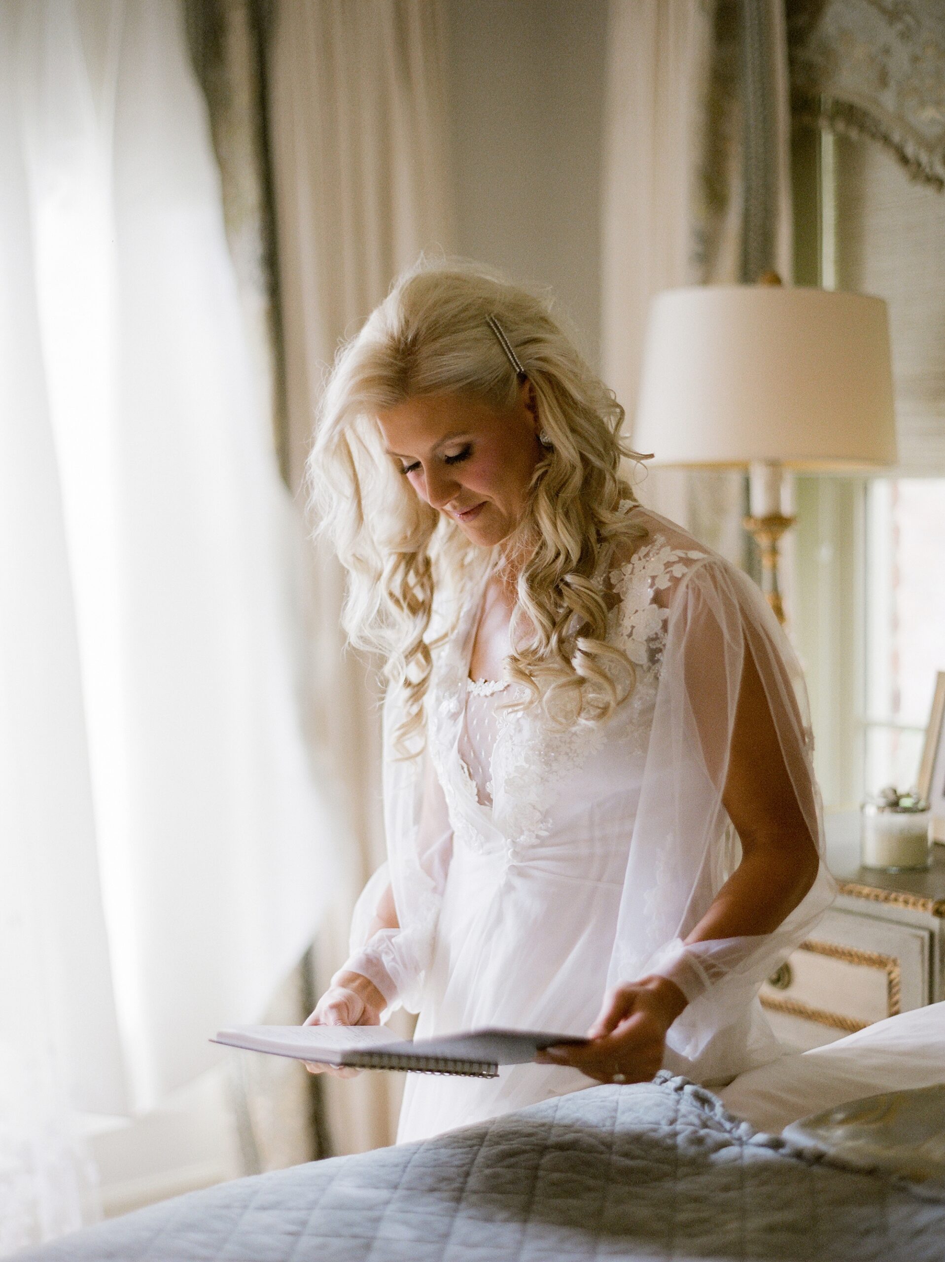 bride looks at gift on wedding morning in Lafayette LA