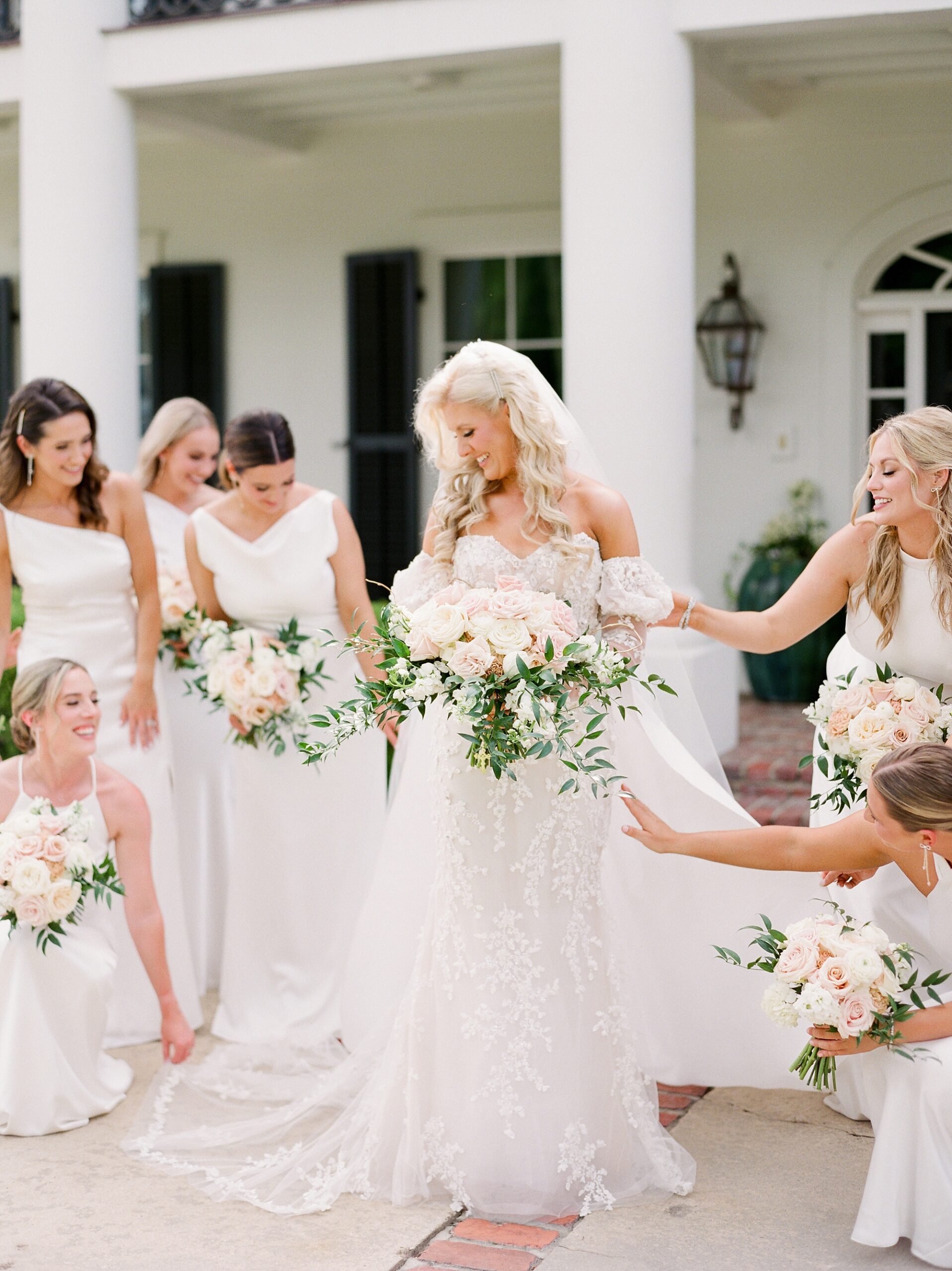 bridesmaids adjust wedding gown for bride outside the University of Louisiana at Lafayette alumni center