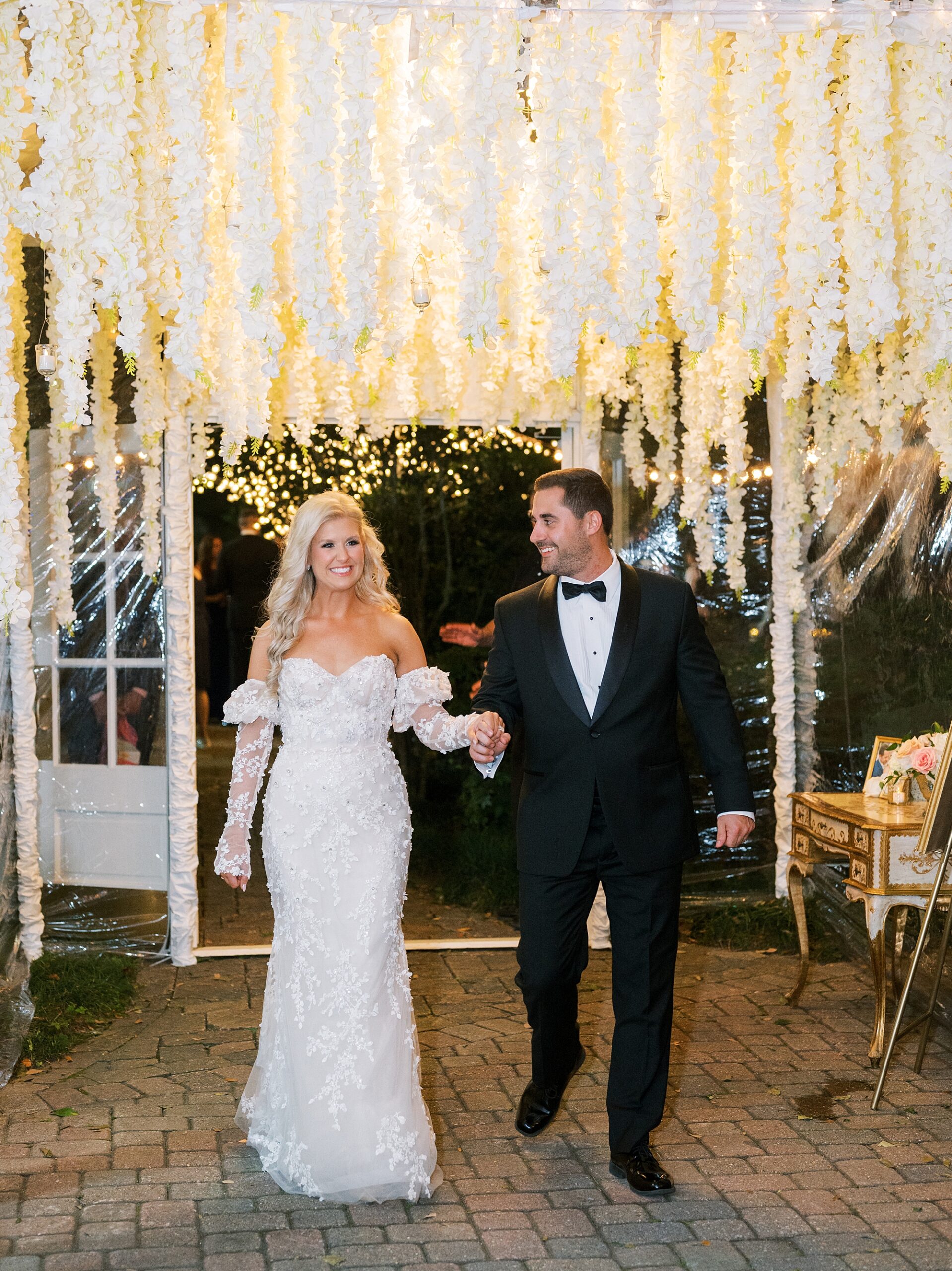 bride and groom walk into tented reception at the University of Louisiana at Lafayette alumni center