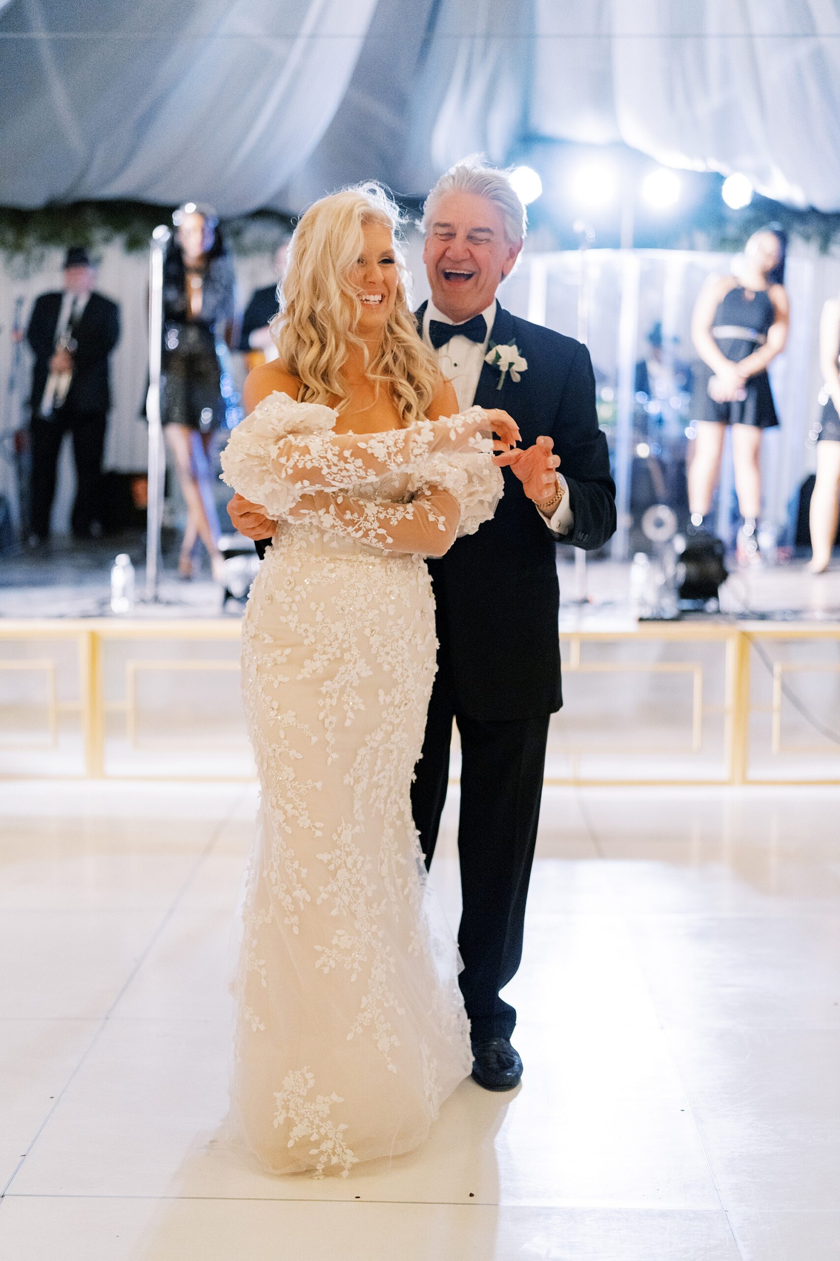 father twirls daughter on dance floor at reception 