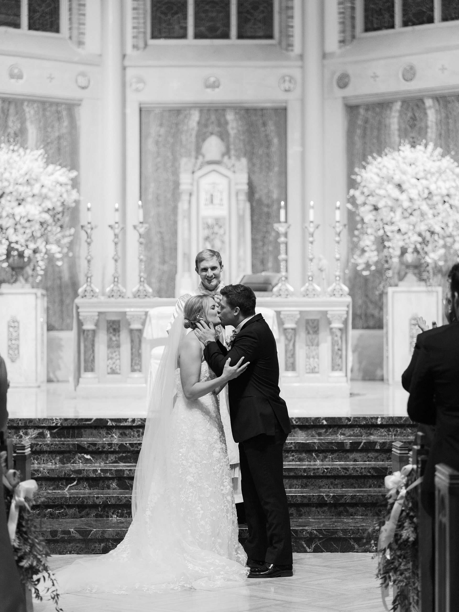 newlyweds kiss during wedding ceremony inside the Cathedral of St. John the Evangelist