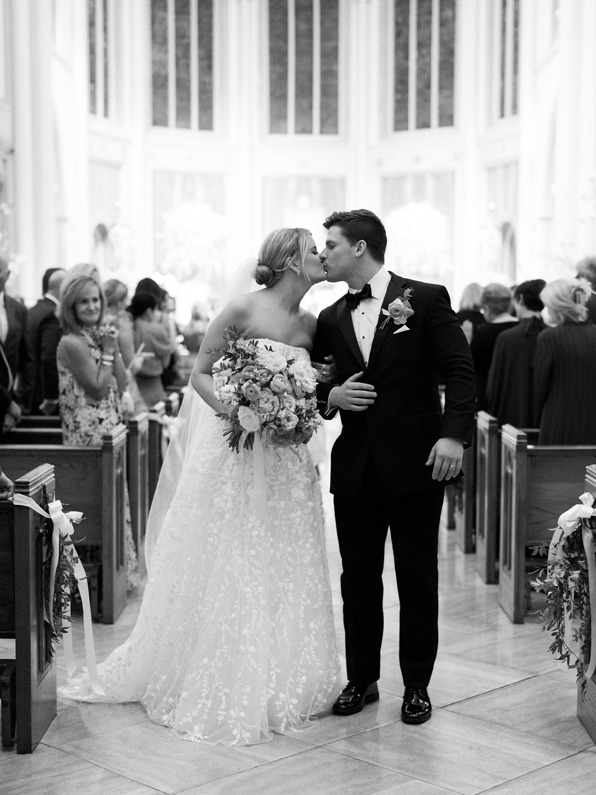 newlyweds kiss in aisle after ceremony at the Cathedral of St. John the Evangelist