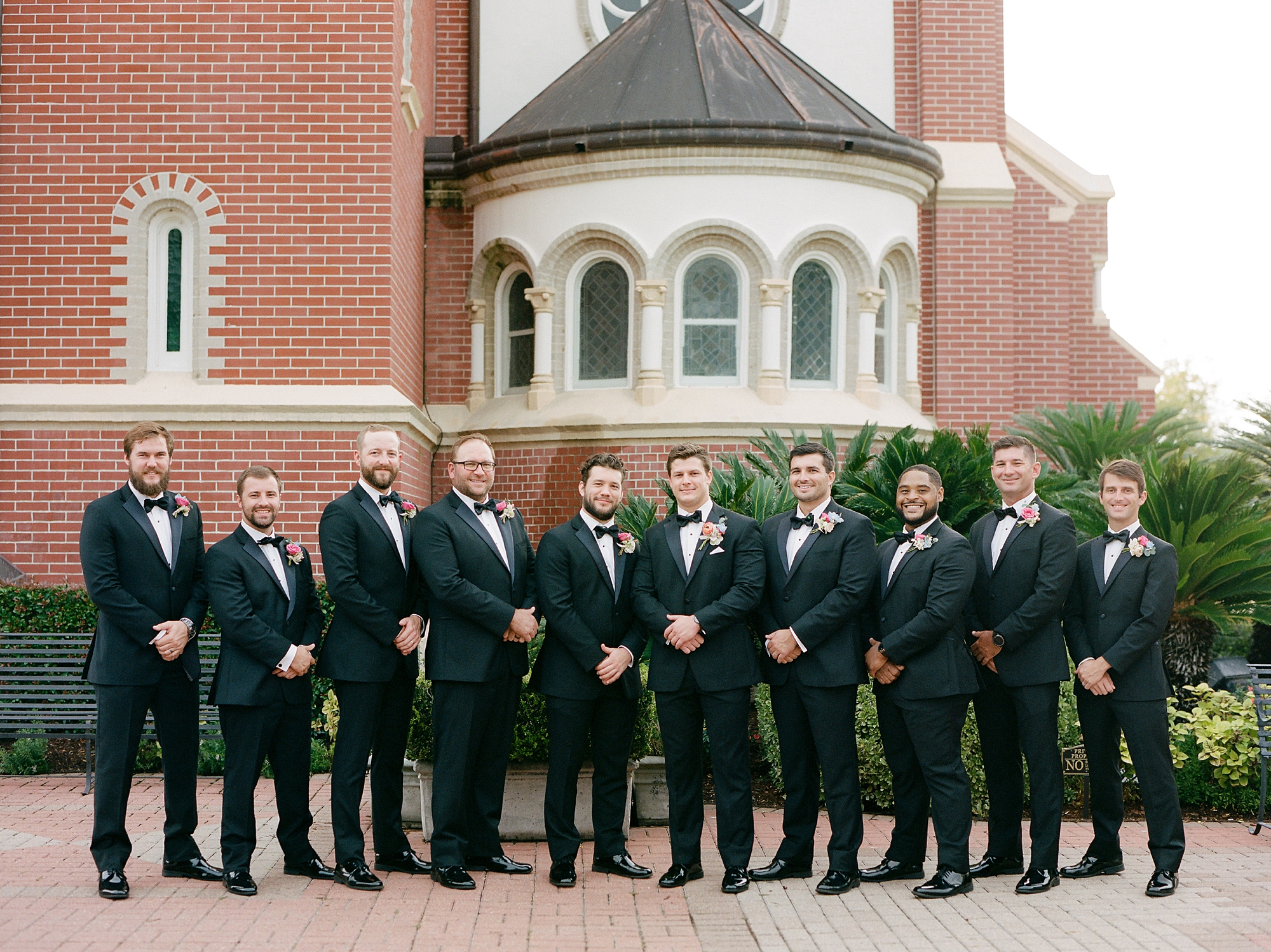 groom poses with groomsmen outside the Cathedral of St. John the Evangelist