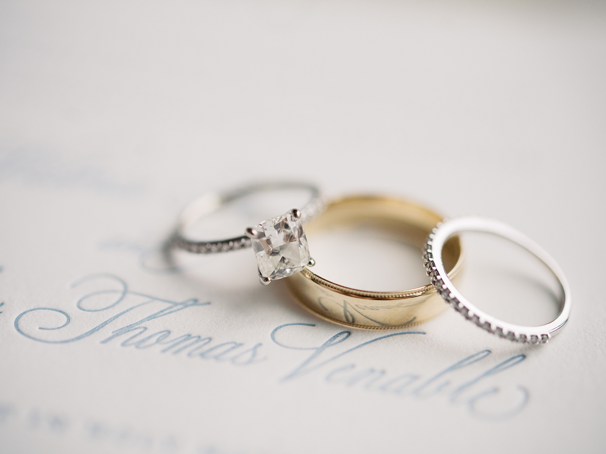 wedding rings lay on invitation for New Orleans wedding 