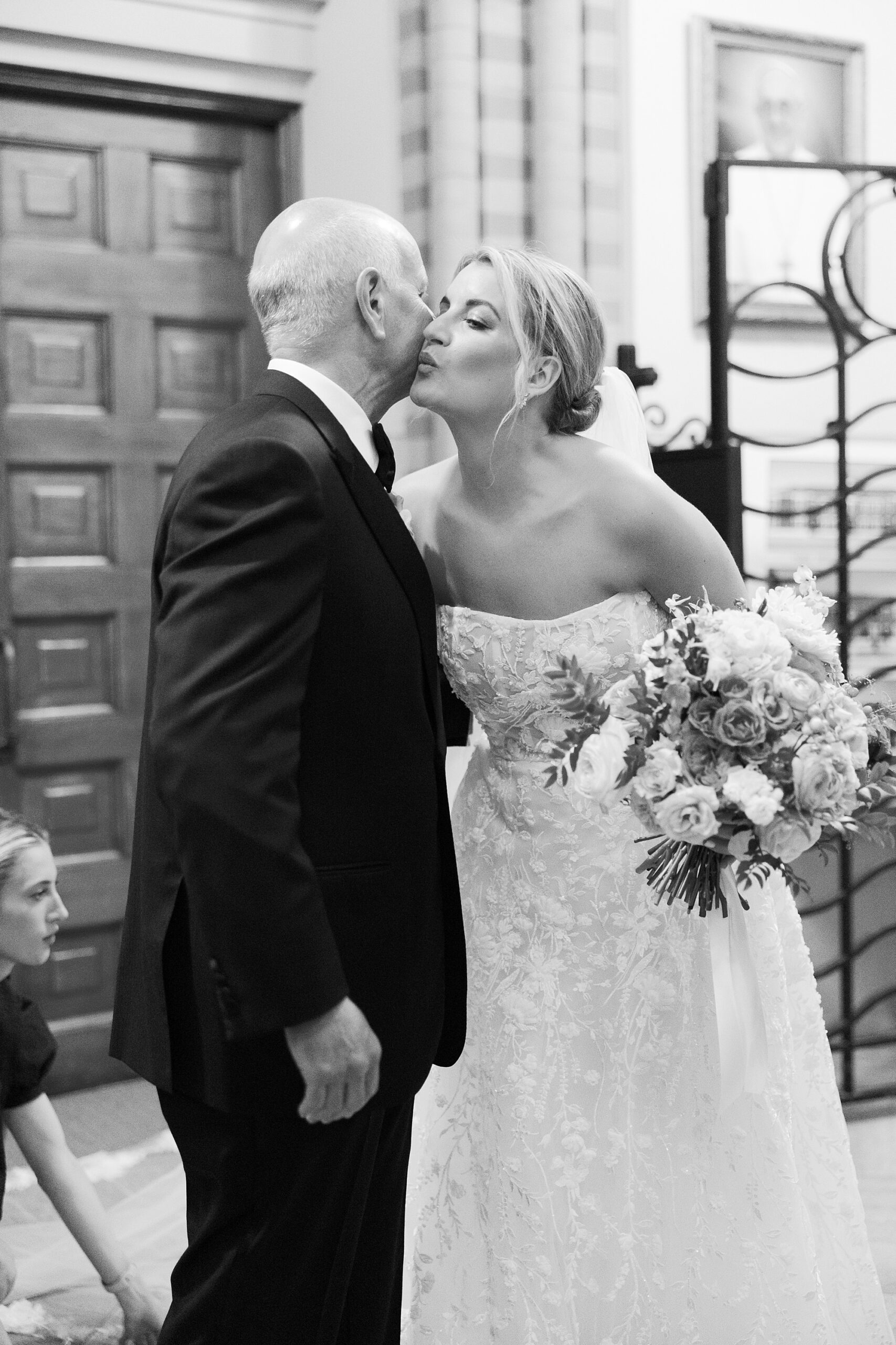 bride kisses dad's cheek inside  St. John’s Cathedral