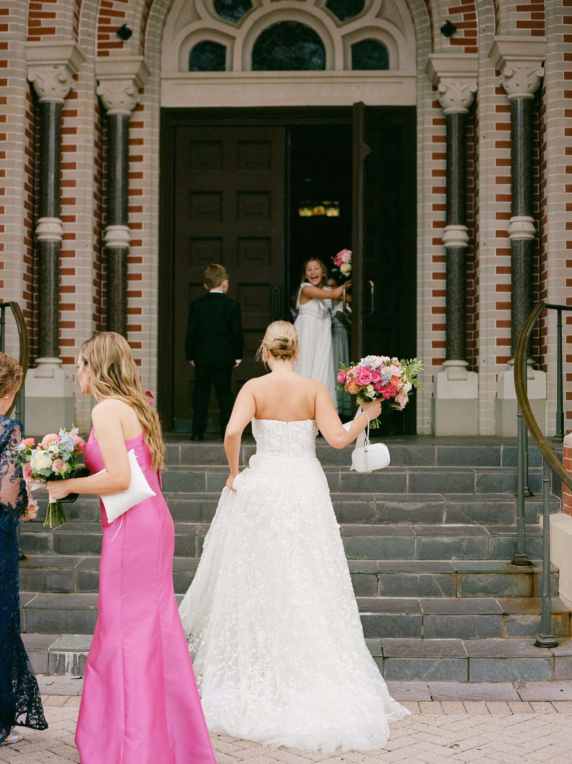 bride walks up steps at the Cathedral of St. John the Evangelist
