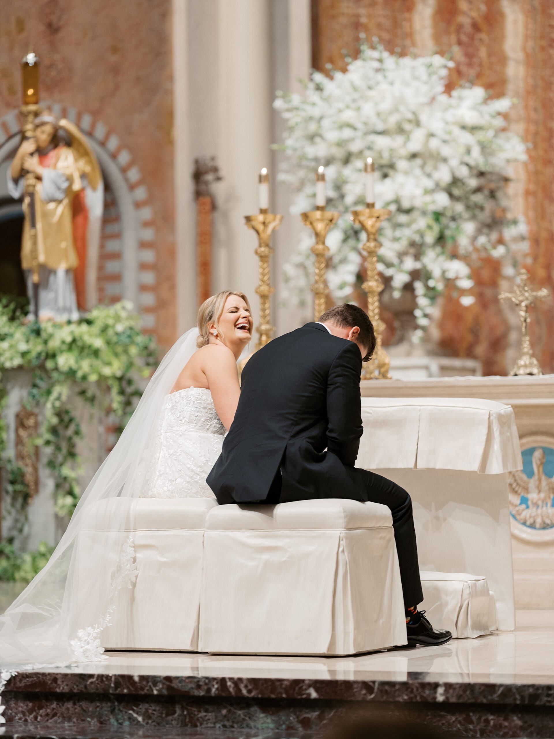 bride and groom laugh during traditional ceremony at the Cathedral of St. John the Evangelist