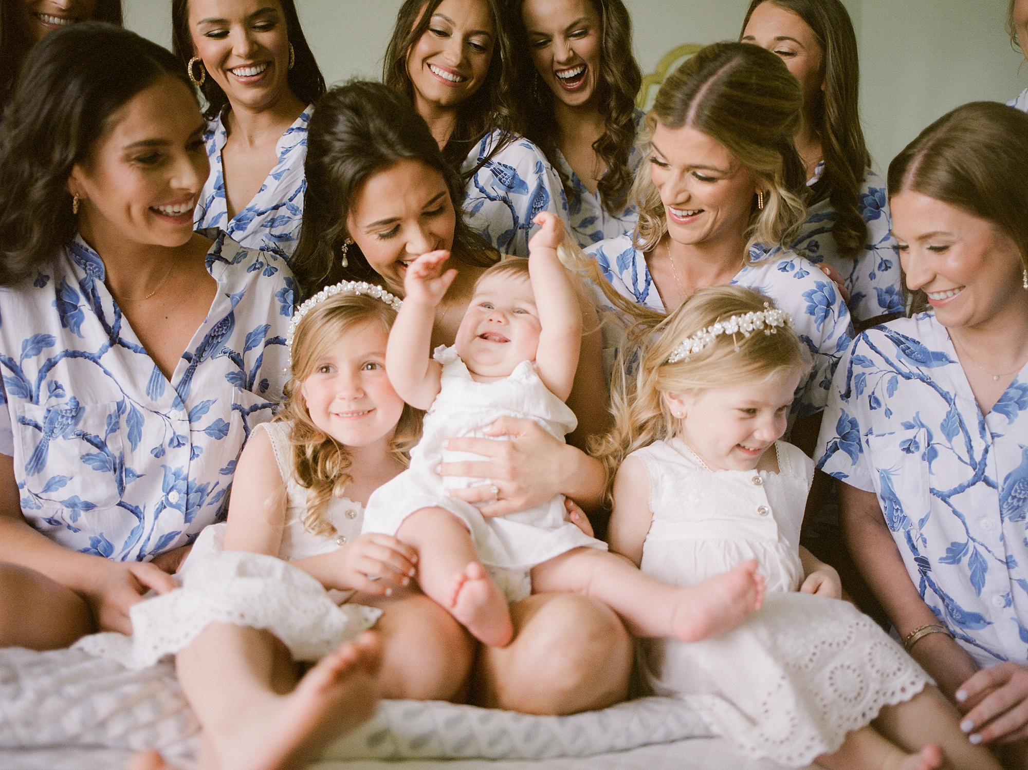 bride poses on bride with bridesmaids and flower girls