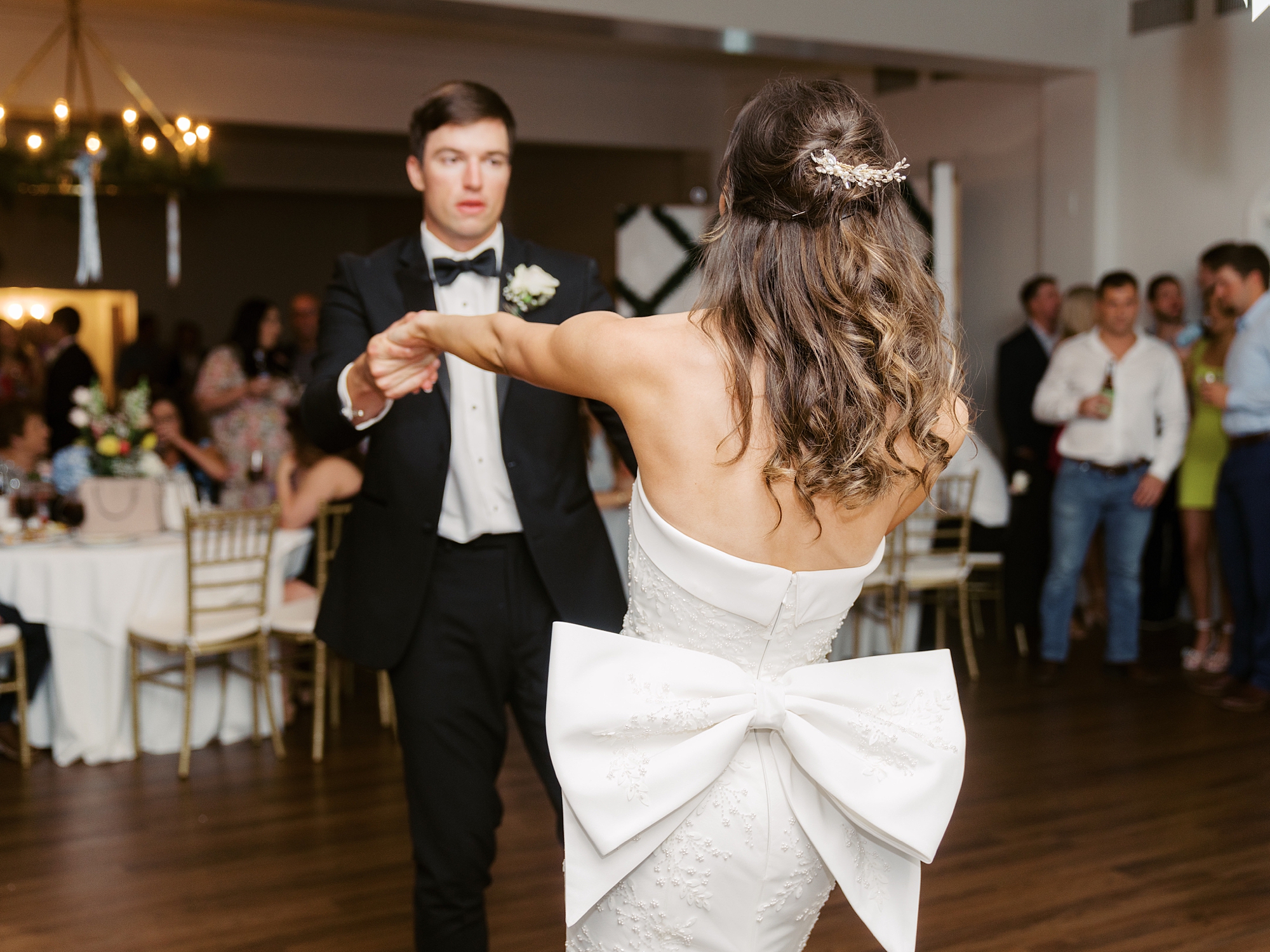 groom twirls bride around wit how on the back of her dress at Oakbourne Country Club