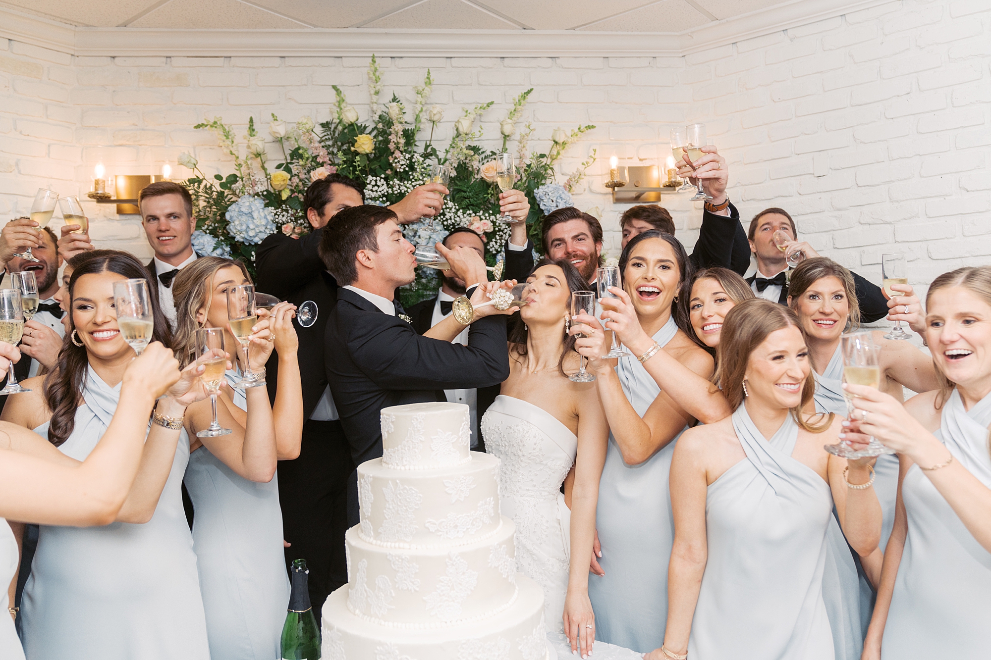 newlyweds drink shots with wedding party near cake at Oakbourne Country Club
