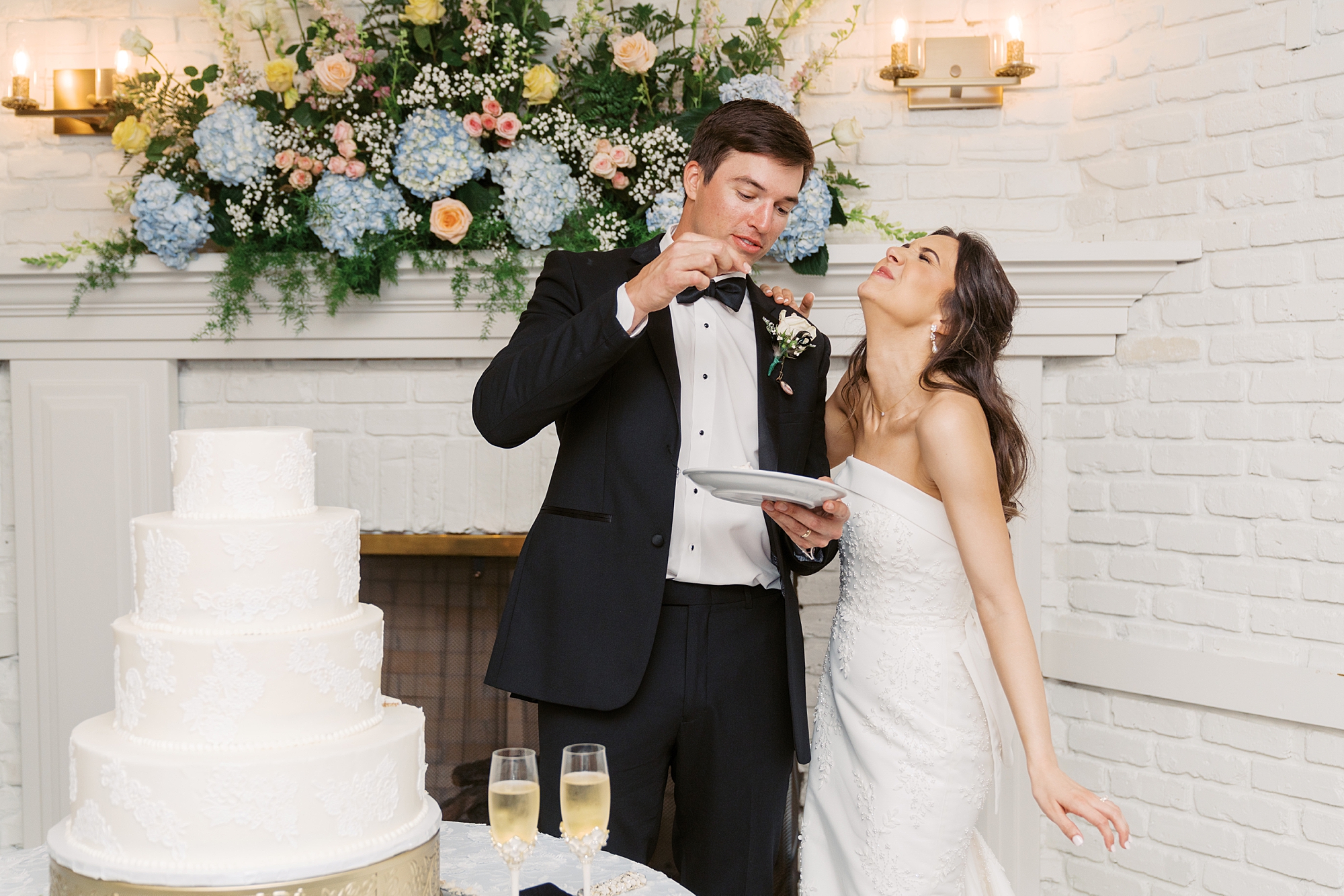 groom serves bride wedding cake during Oakbourne Country Club reception 