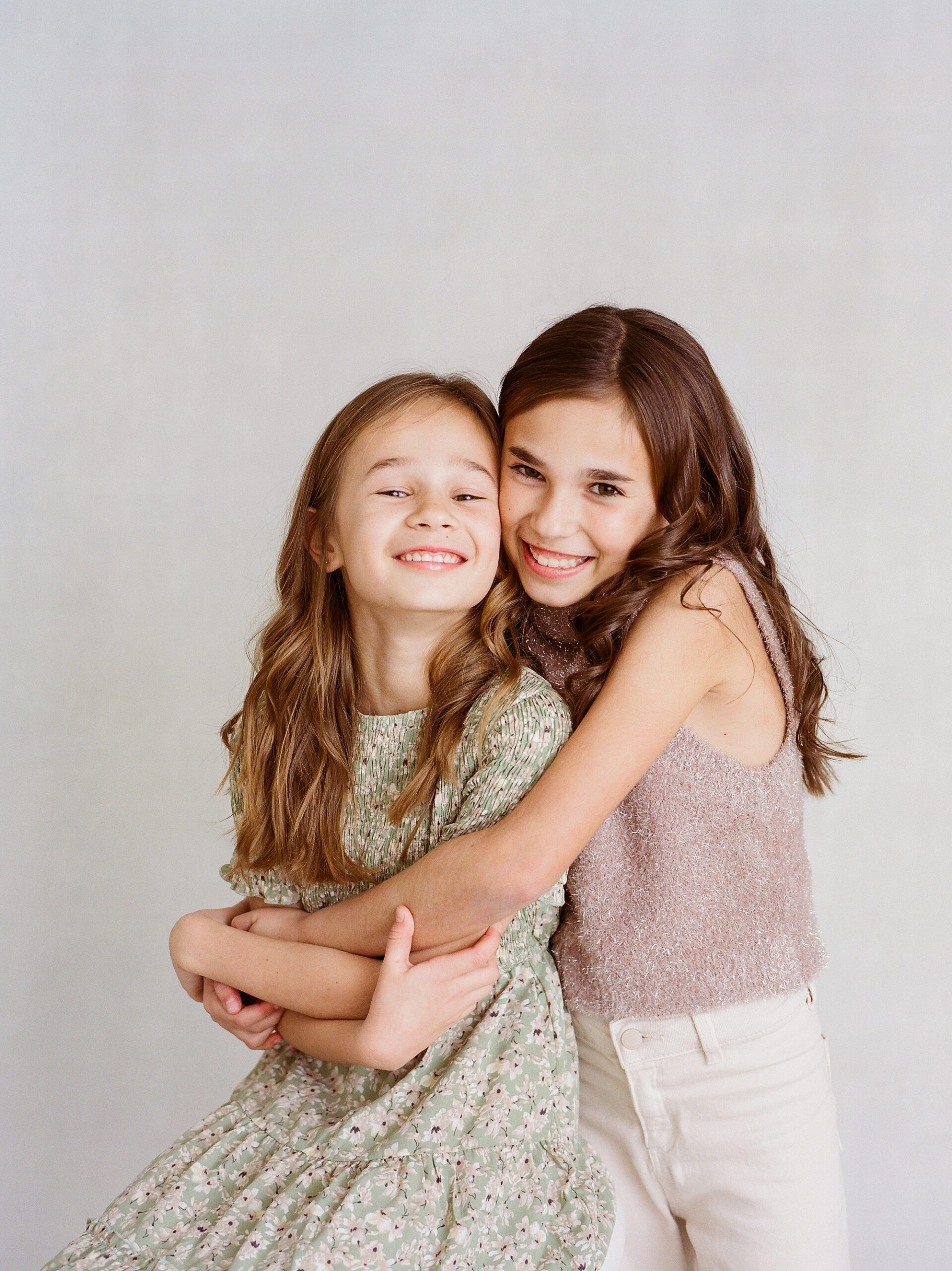 sisters hug together during family photos in Lafayette LA 