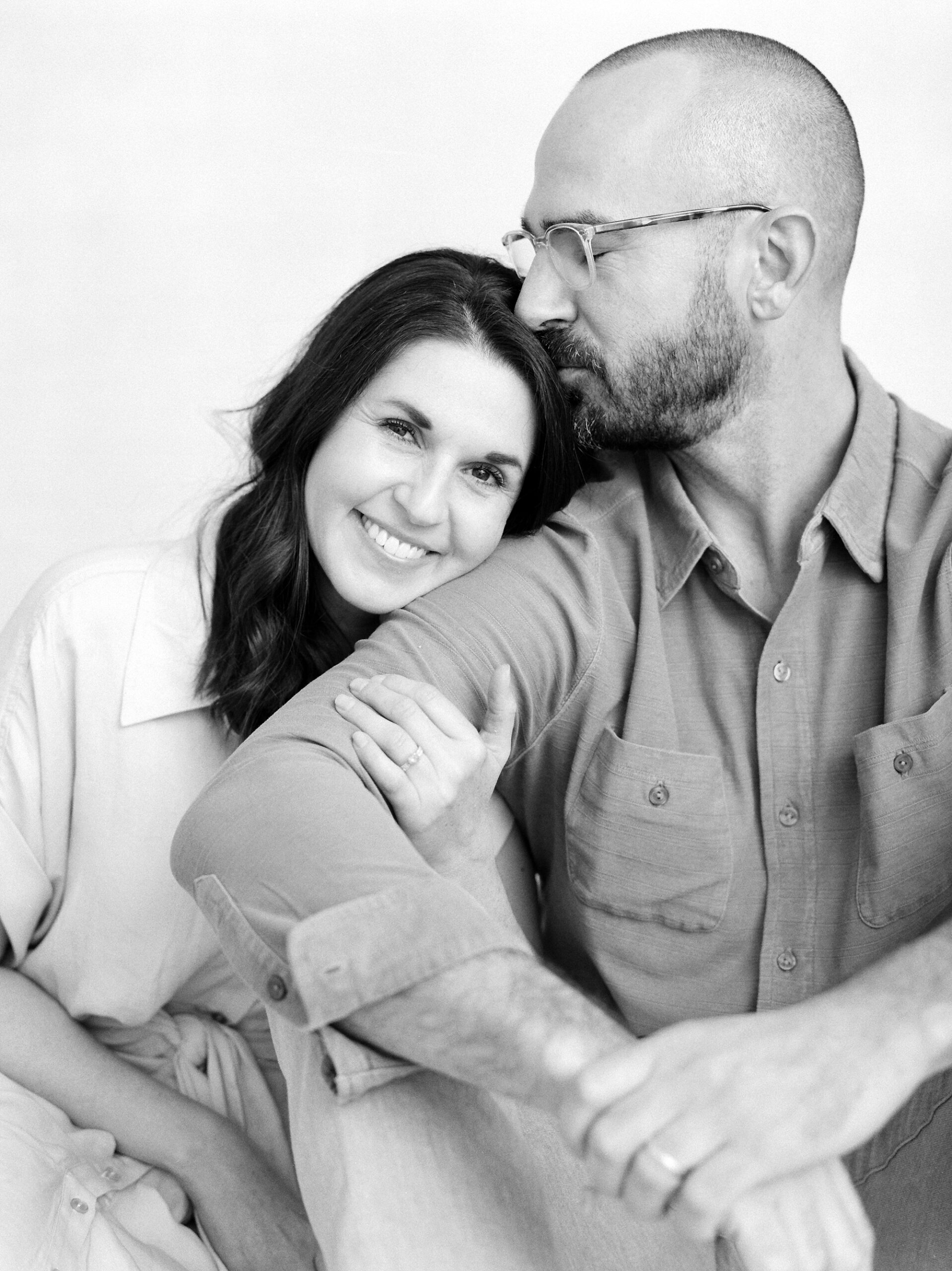 woman hugs man's arm during studio family portraits 