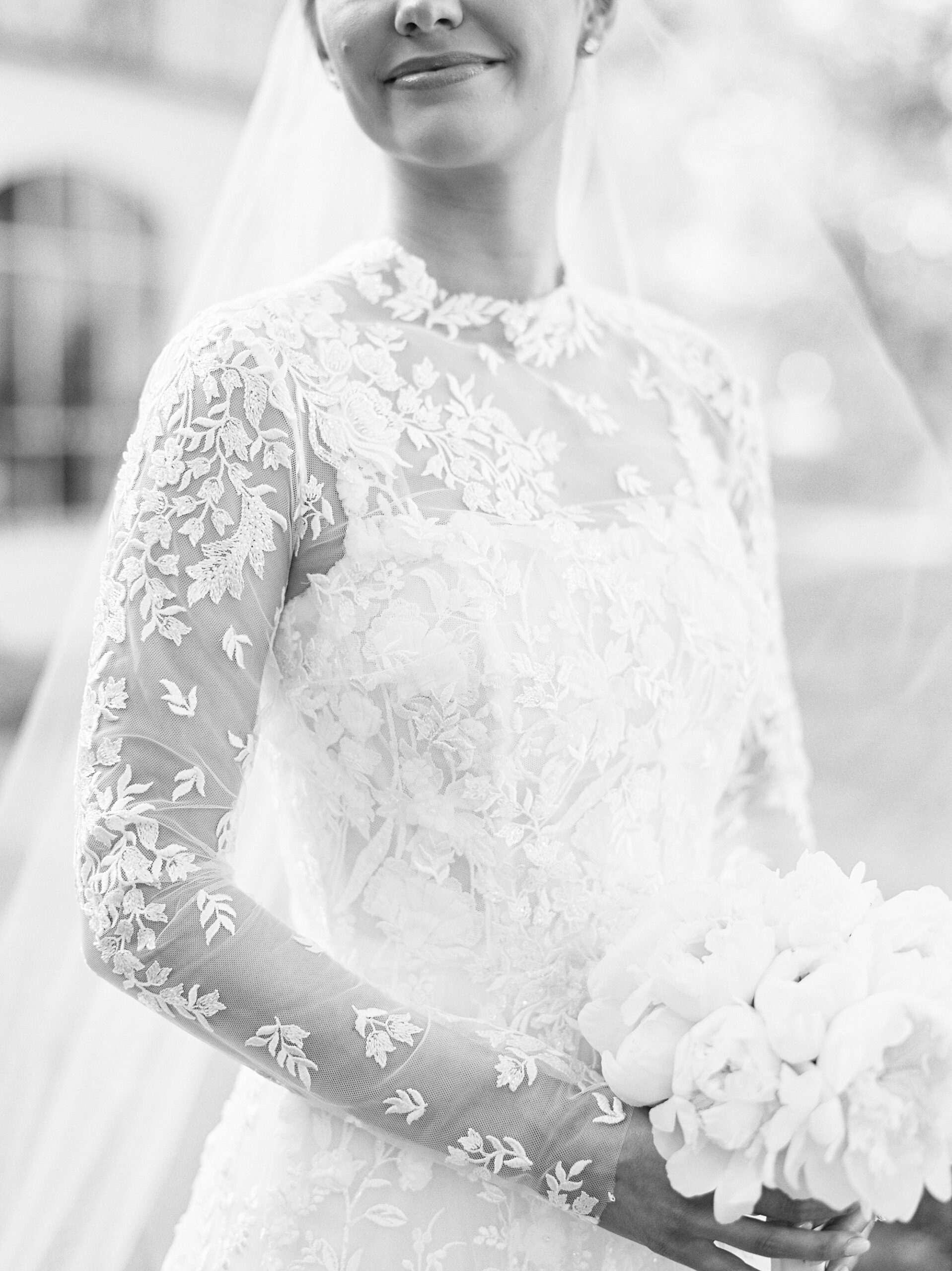 bride stands in wedding dress with lace overlay during UL Alumni Center bridal portraits