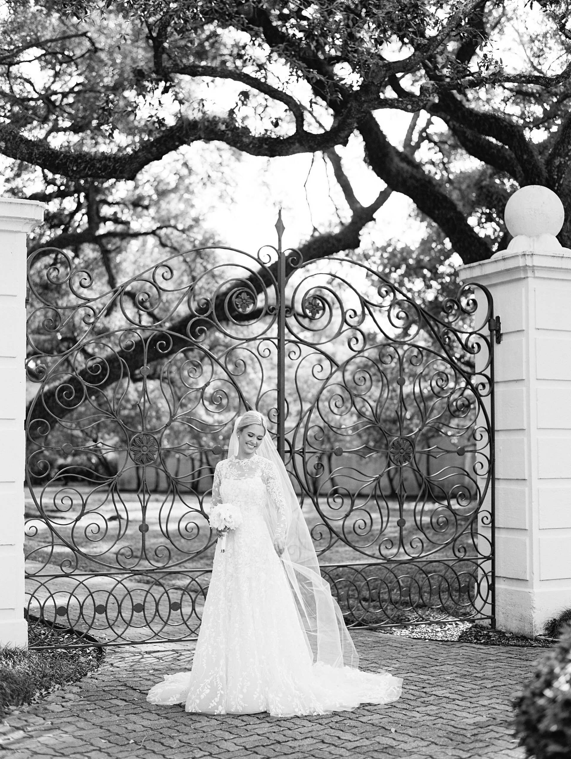 bride stands in front of wrought iron gates during UL Alumni Center bridal portraits