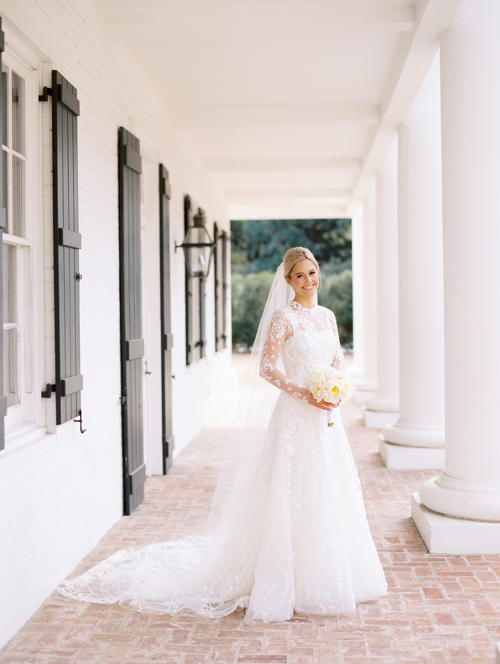 bride holds ivory bouquet under awning at the UL Alumni Center