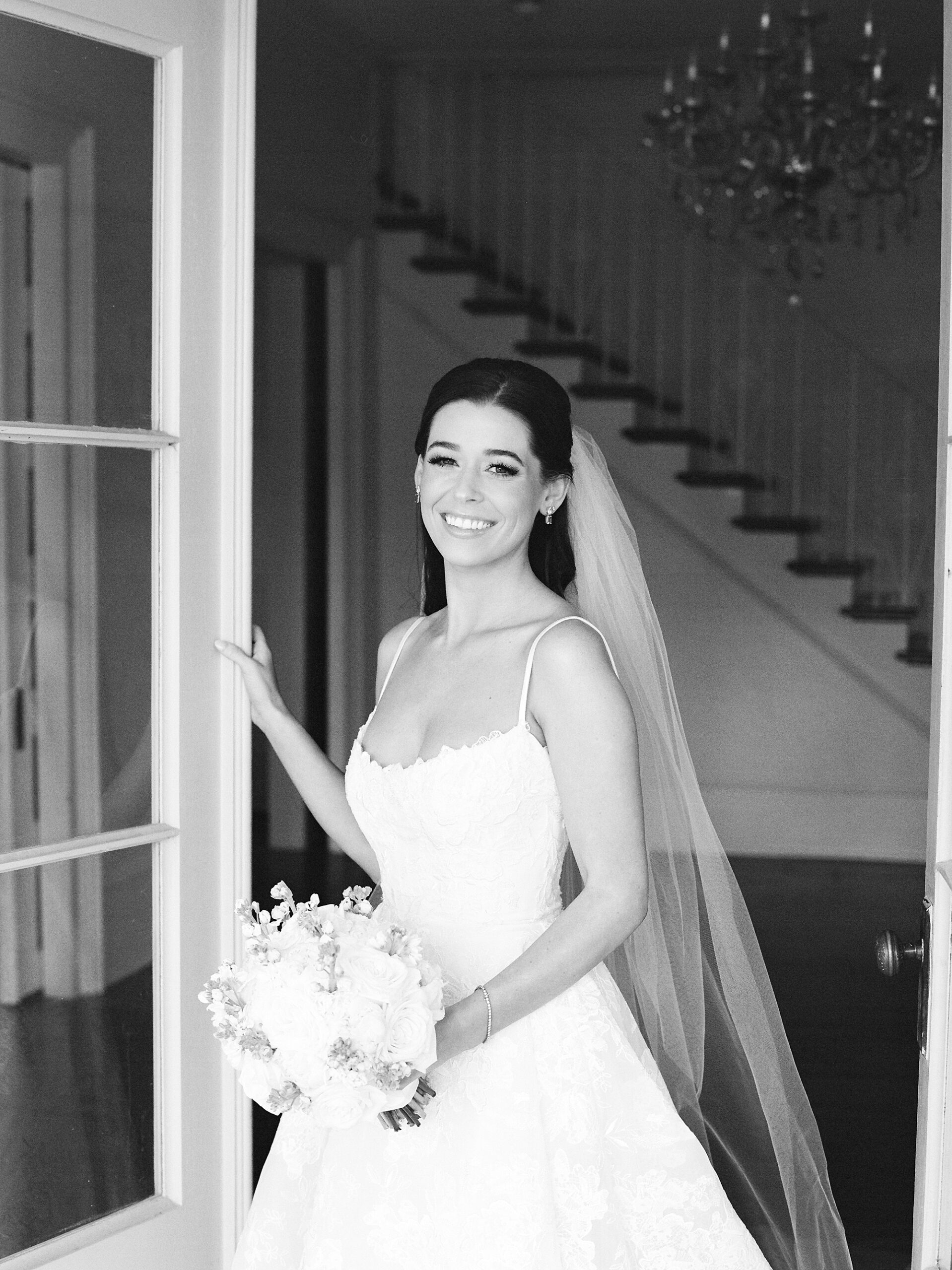 bride poses inside John Nickerson House with veil out behind her 