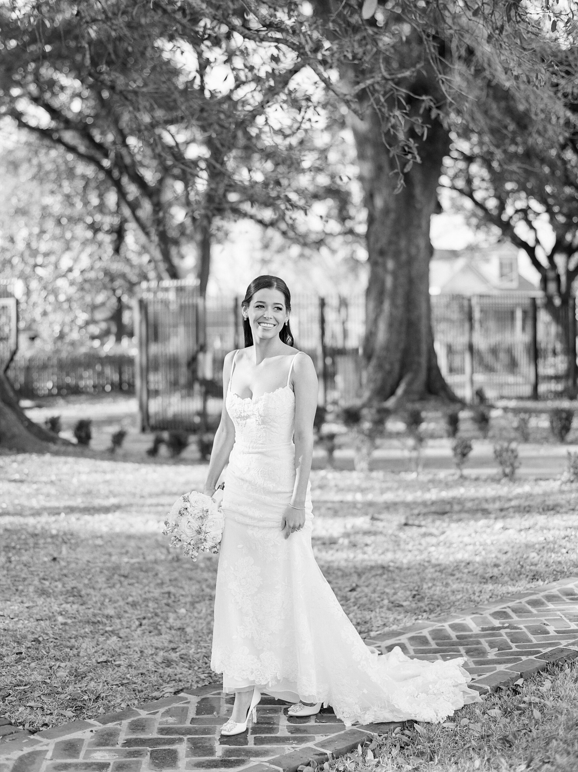 bride stands on lawn and brick pathway at John Nickerson House
