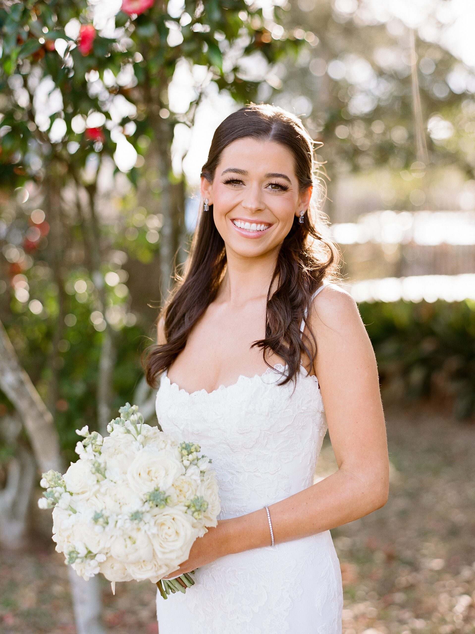 bride smiles holding bouquet of ivory roses during bridal portraits at John Nickerson House