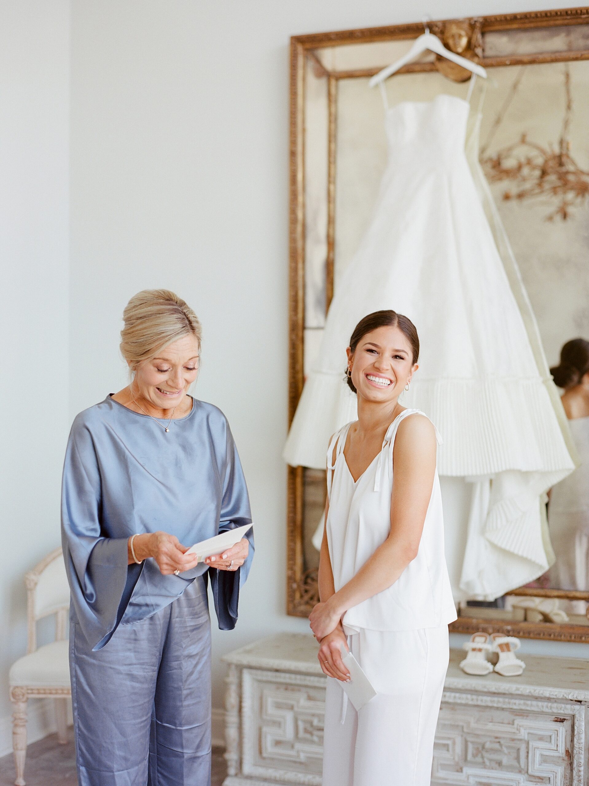 bride and mom laugh during letter exchange during Lafayette LA wedding prep