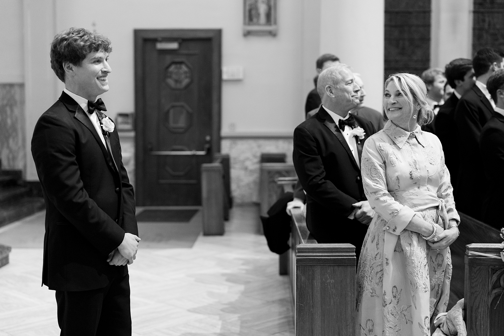 mother looks at groom during wedding ceremony at St. John Cathedral