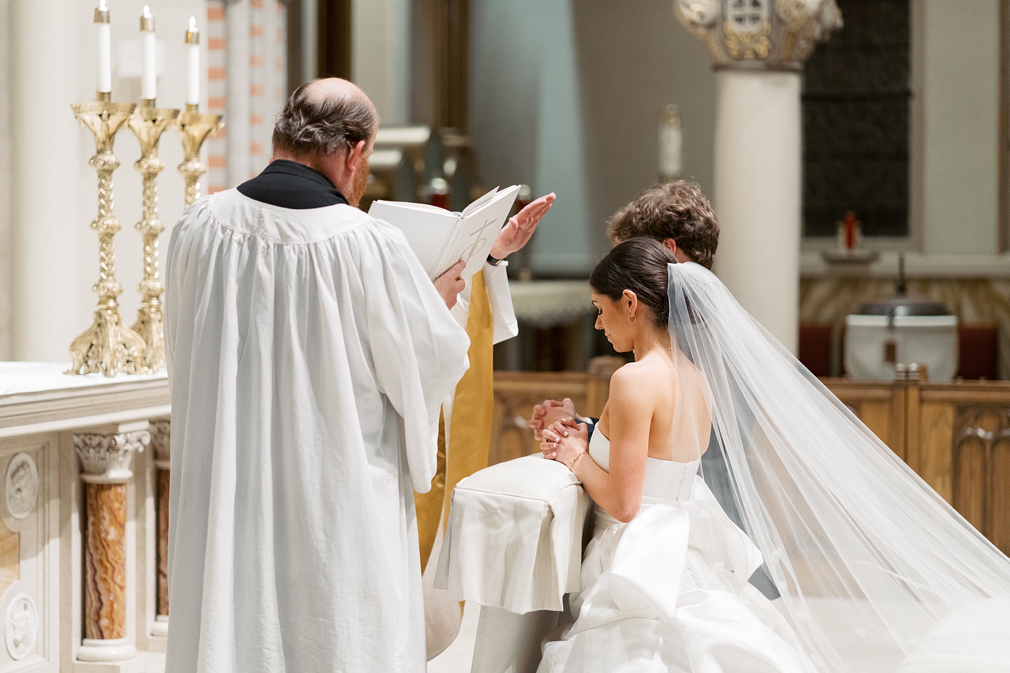 priest blesses couple during wedding ceremony at St. John Cathedral