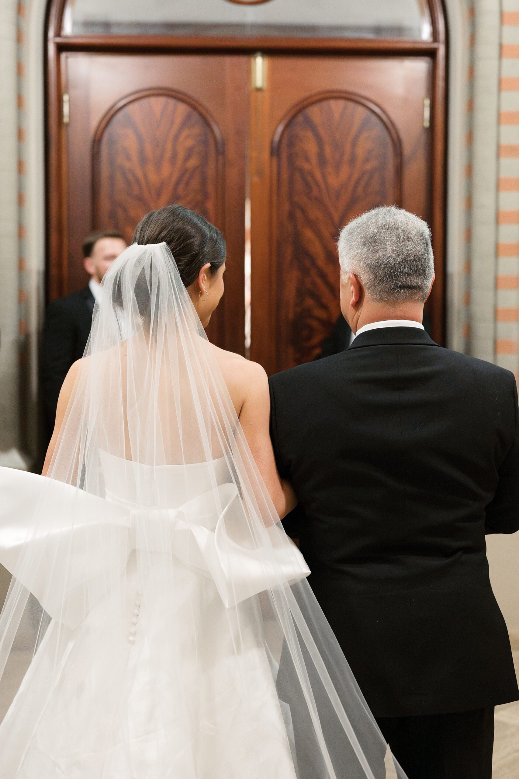 father walks bride into wedding ceremony at St. John's Cathedral