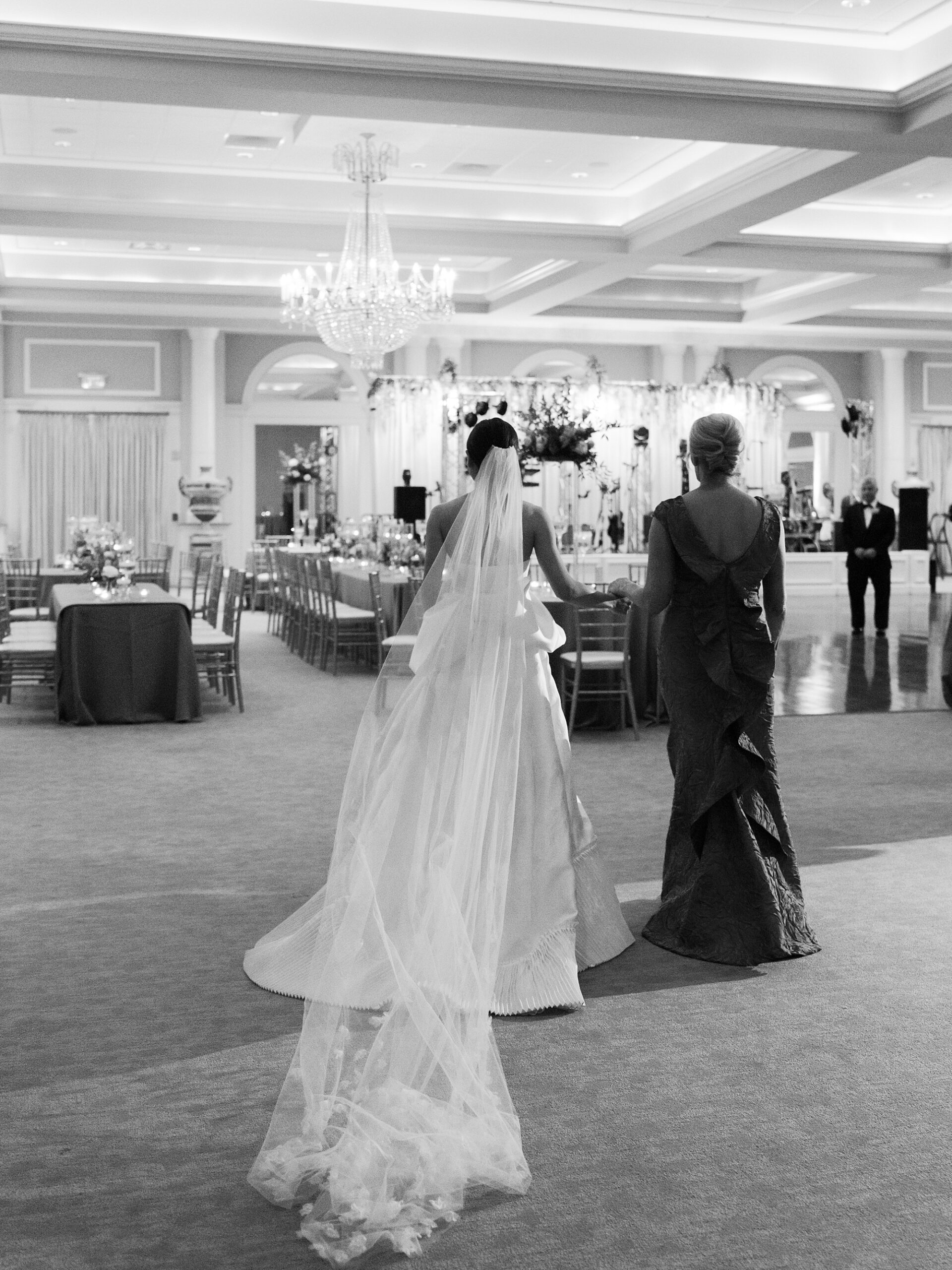 bride walks with mother into reception at Le Pavillon