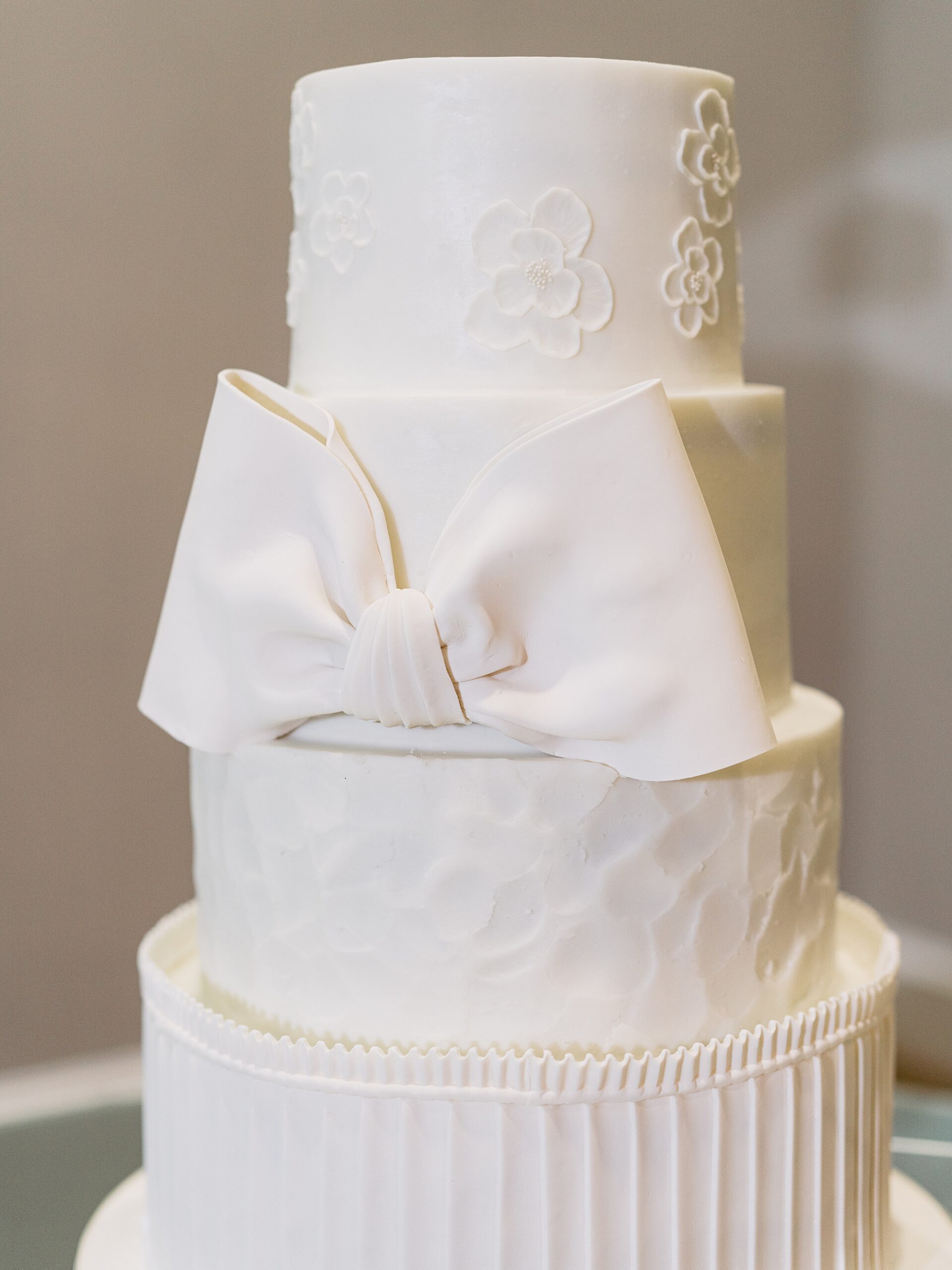 tiered wedding cake with bow at wedding reception at Le Pavillon