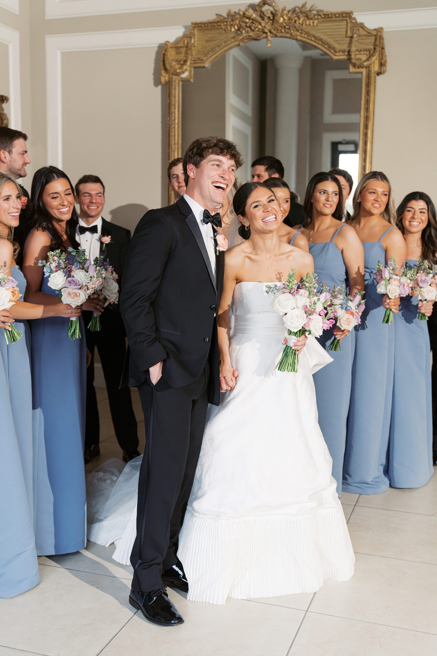 bride smiles with bridesmaids in blue gowns at Le Pavillon